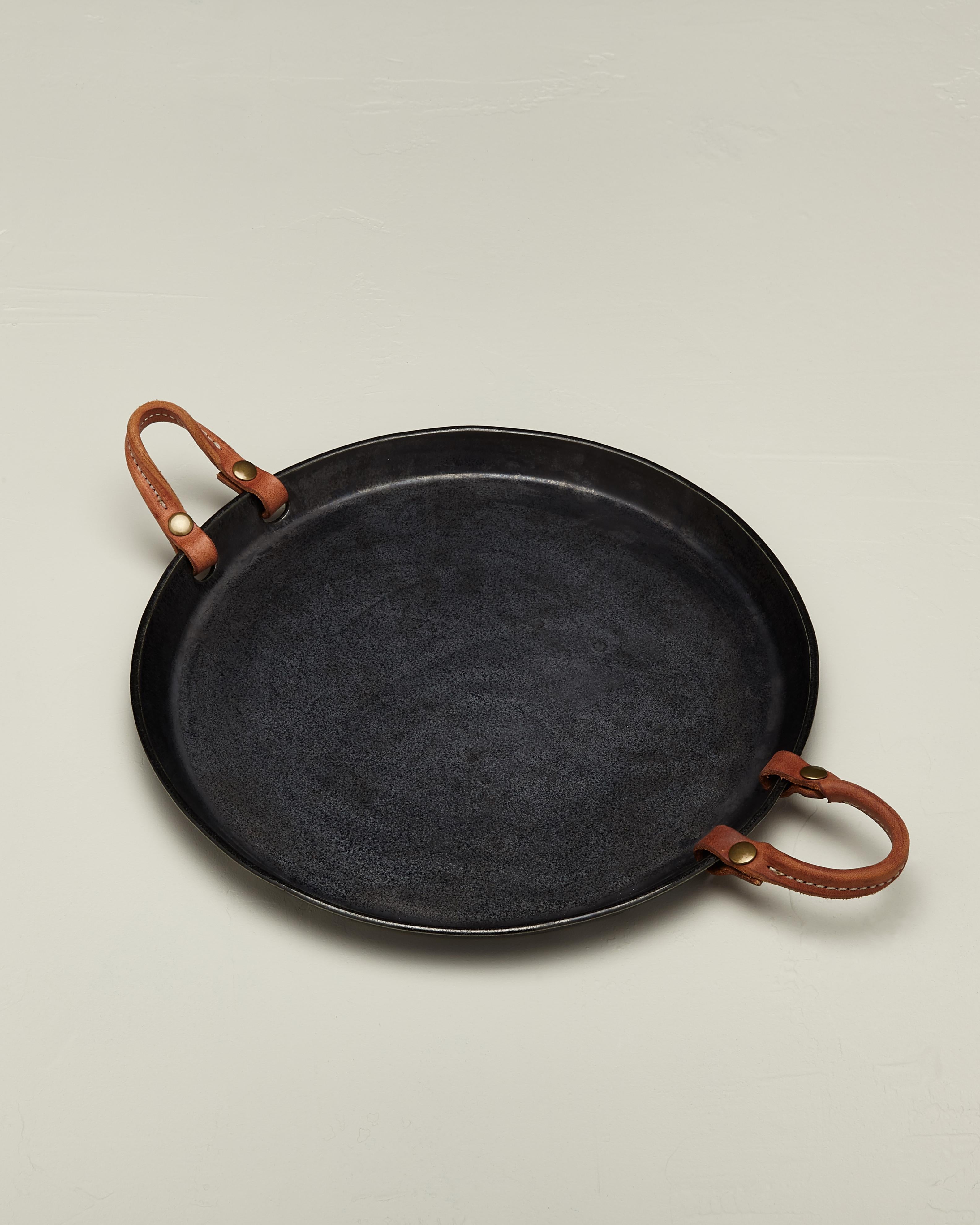 The porcelain Remo tray features stitched leather handles with snaps you can easily remove for cleaning then snap right back on. The perfect tray for all of your entertaining needs, sleek and beautiful. There will be variation in size, leather and