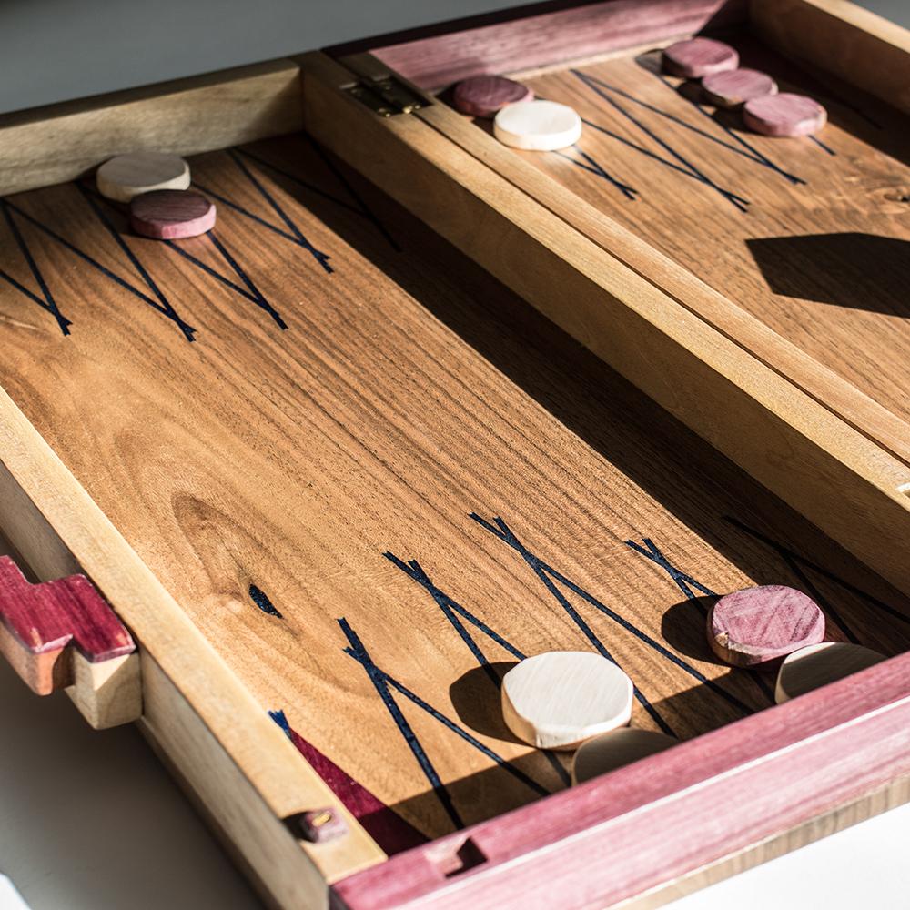 Le jeu de société, entièrement fabriqué à la main, est composé de bois de noyer, d'érable et de Roxinho. Le bois de Roxinho, le violet, provient de l'Amazonie et est certifié. Il s'agit d'un produit très spécial, unique et traité de manière
