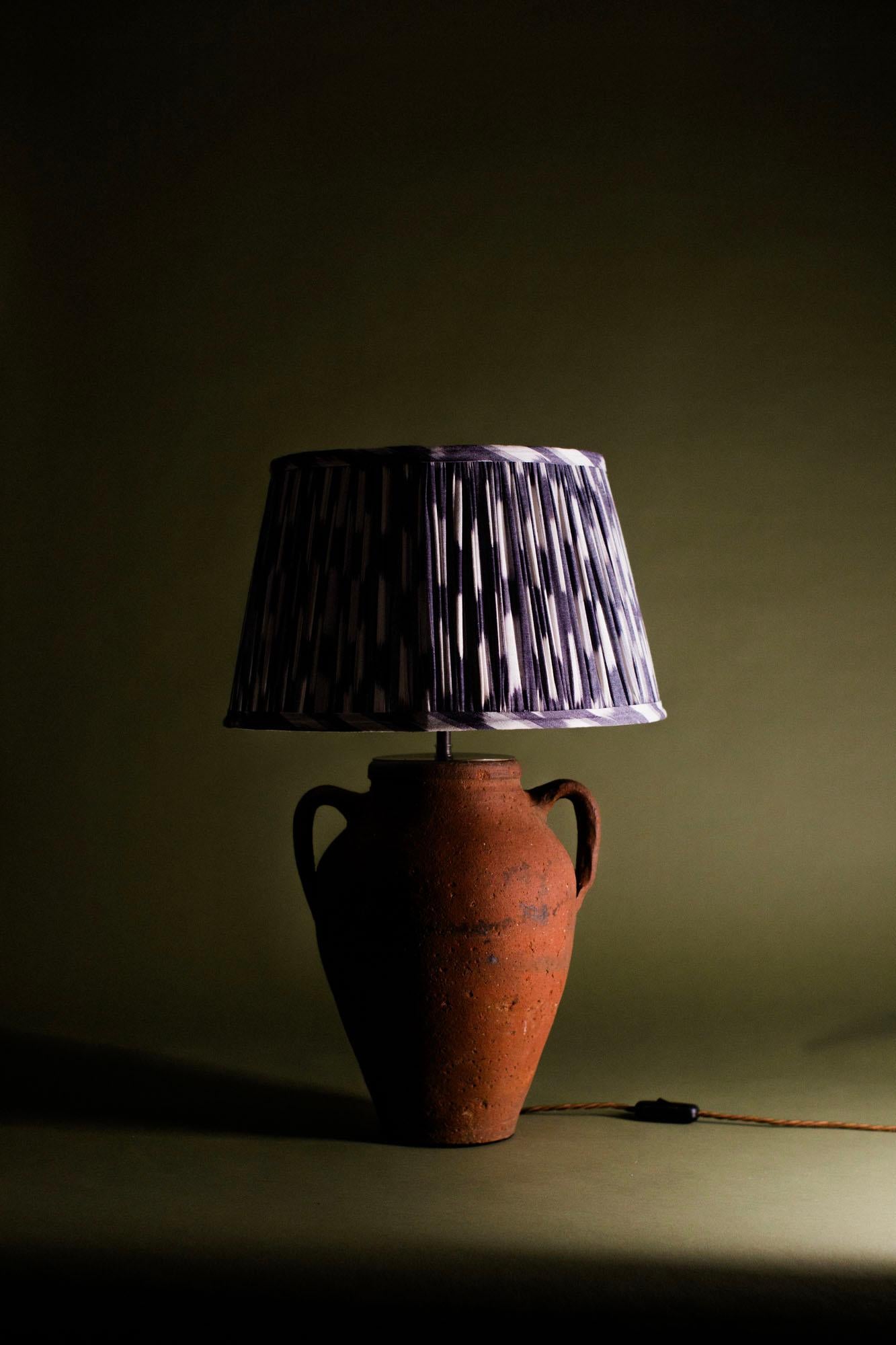Lampe de table vintage en terre cuite turque, fabriquée à la main au 20e siècle selon les techniques traditionnelles d'Anatolie. La lampe présente une finition en terre cuite d'un rouge profond, typique des poteries de la région de Cappadoce en