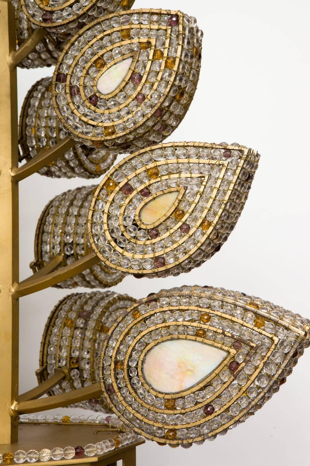Handcrafted chandelier composed of a gold colored iron frame interlaced by more than 5,000 faceted glass beads and Madre Pearl like Stained Glass on Center of Each Leaf.
Each leaf contains a candelabra socket accessible by a hinged door. Conical