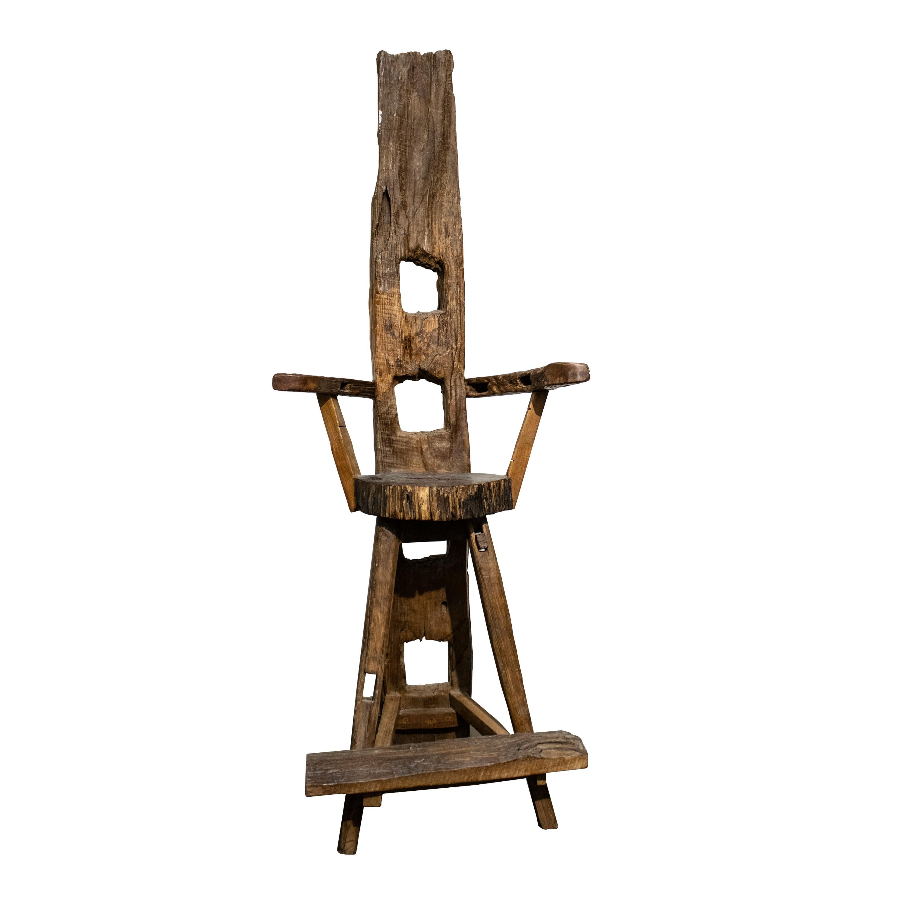 Sculptural walnut and olive wood chair with curved armrest.
Hand-crafted work made with the remains of old farm implements in Germany in the 1920s.
It consists of a specially high backrest with rectangular holes and engraving details.