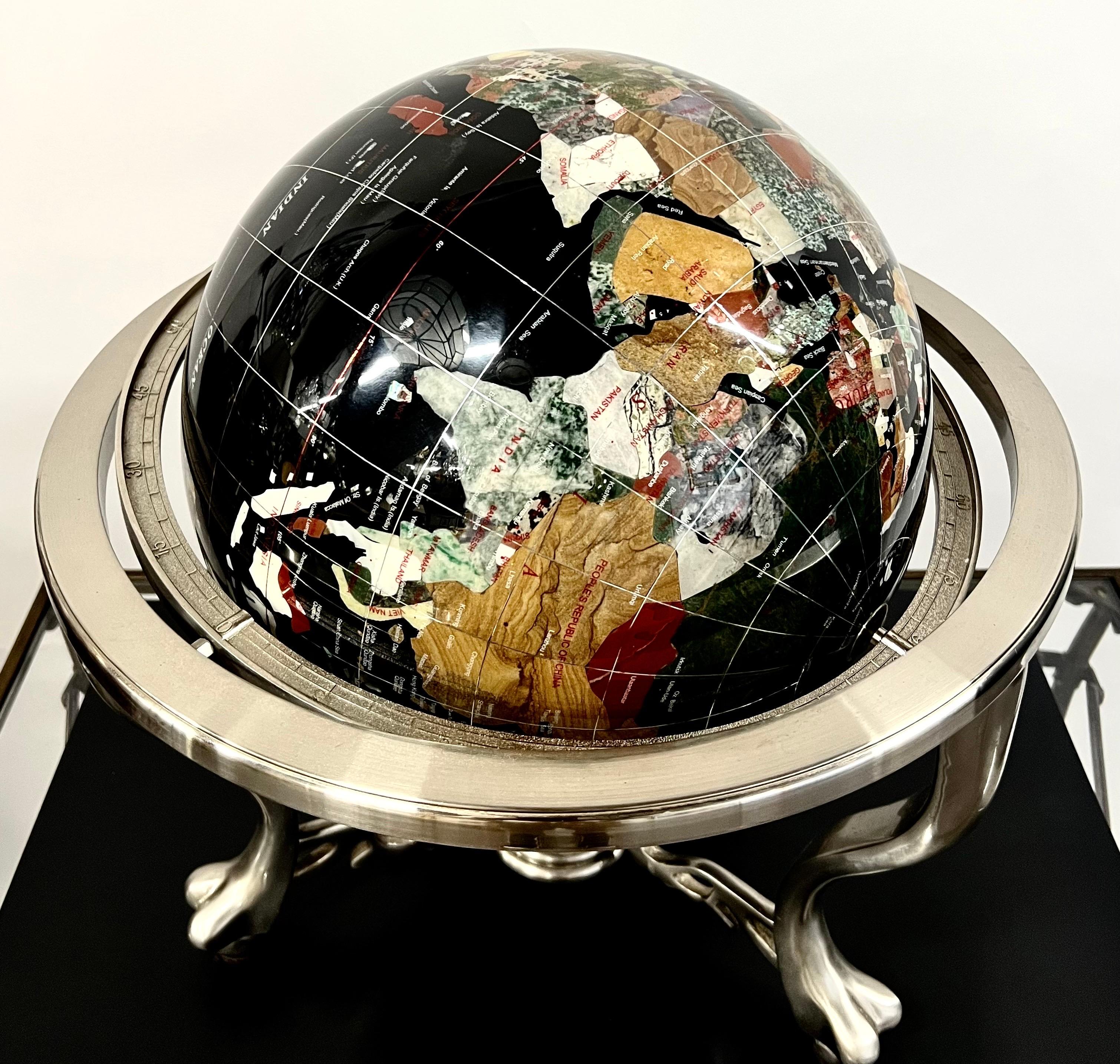 
Handcrafted Semi-Precious Stone Globe on Decorative Metal Stand with Central Compass

This magnificent handcrafted globe is a true work of art, blending cartographic elegance with fine craftsmanship. The sphere is meticulously inlaid with over 30