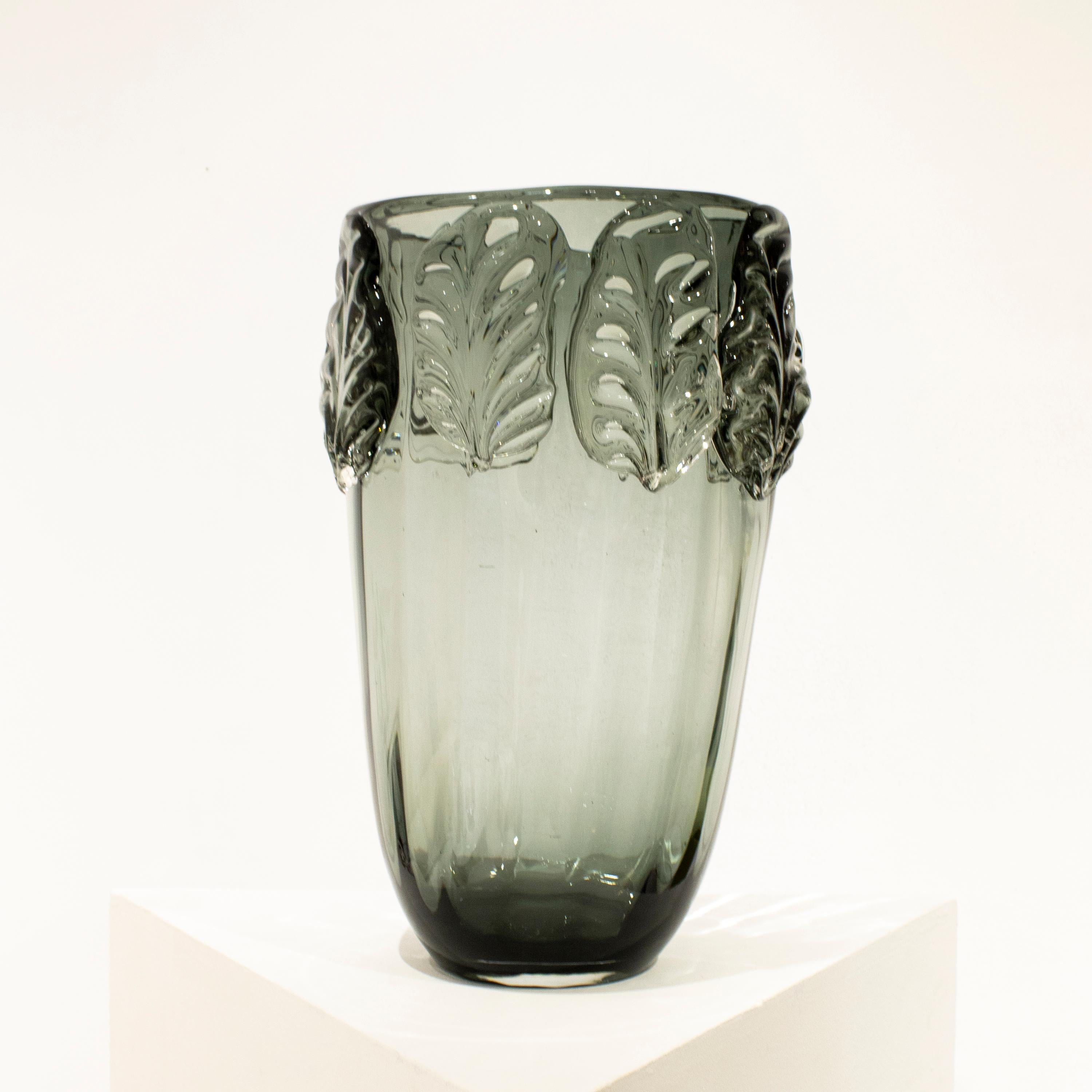 Vase en verre semi-transparent gris italien soufflé à la main, avec des formes organiques et des motifs végétaux. 