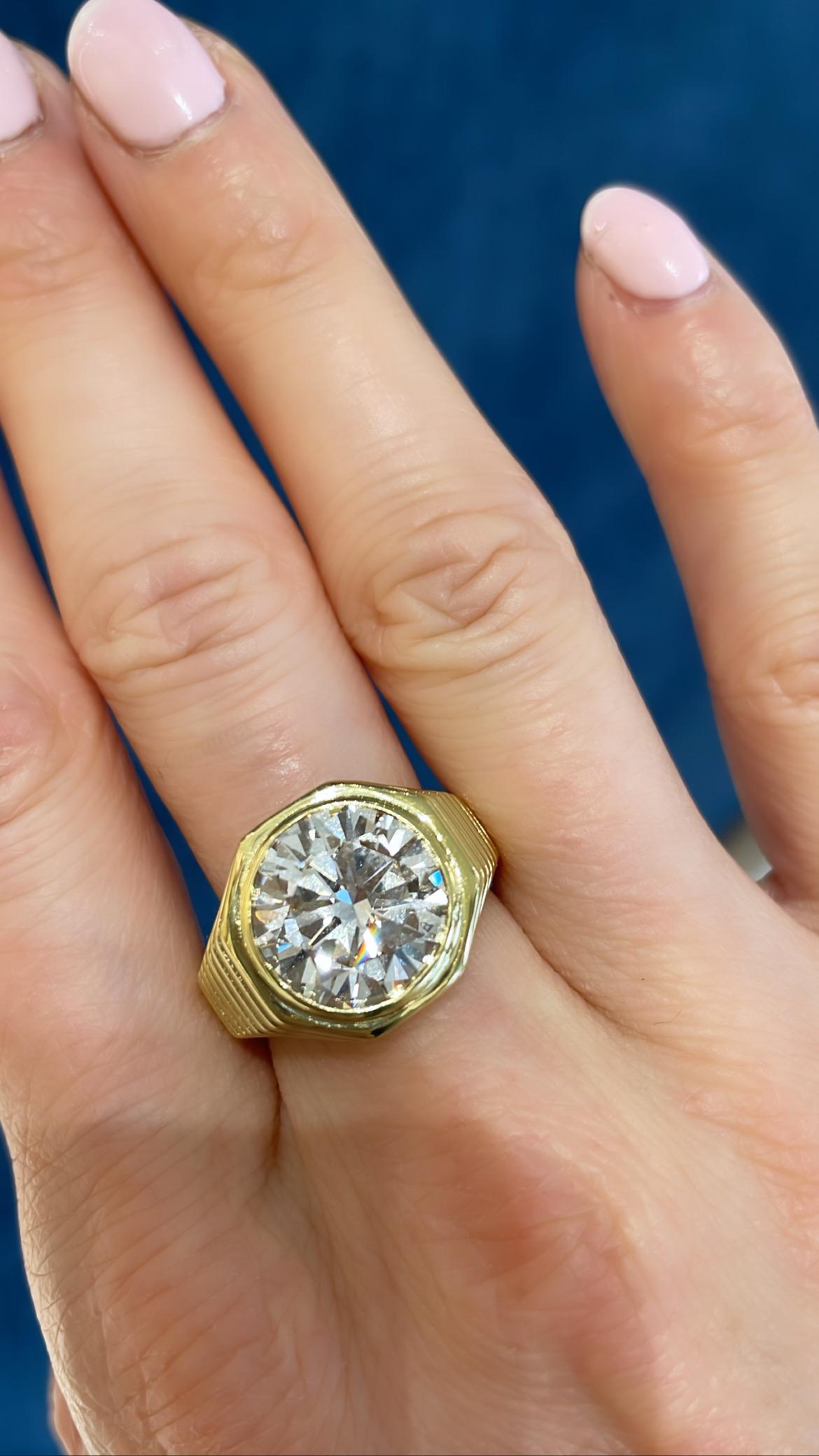 A gorgeous 5.39 ct round shaped diamond crimp set in a 18 karat yellow gold signet style engagement ring. Set with a 5.39 carat J color VVS2 clarity Round Shape GIA Cert diamond. 
This signet style ring will accompany you through the decades;