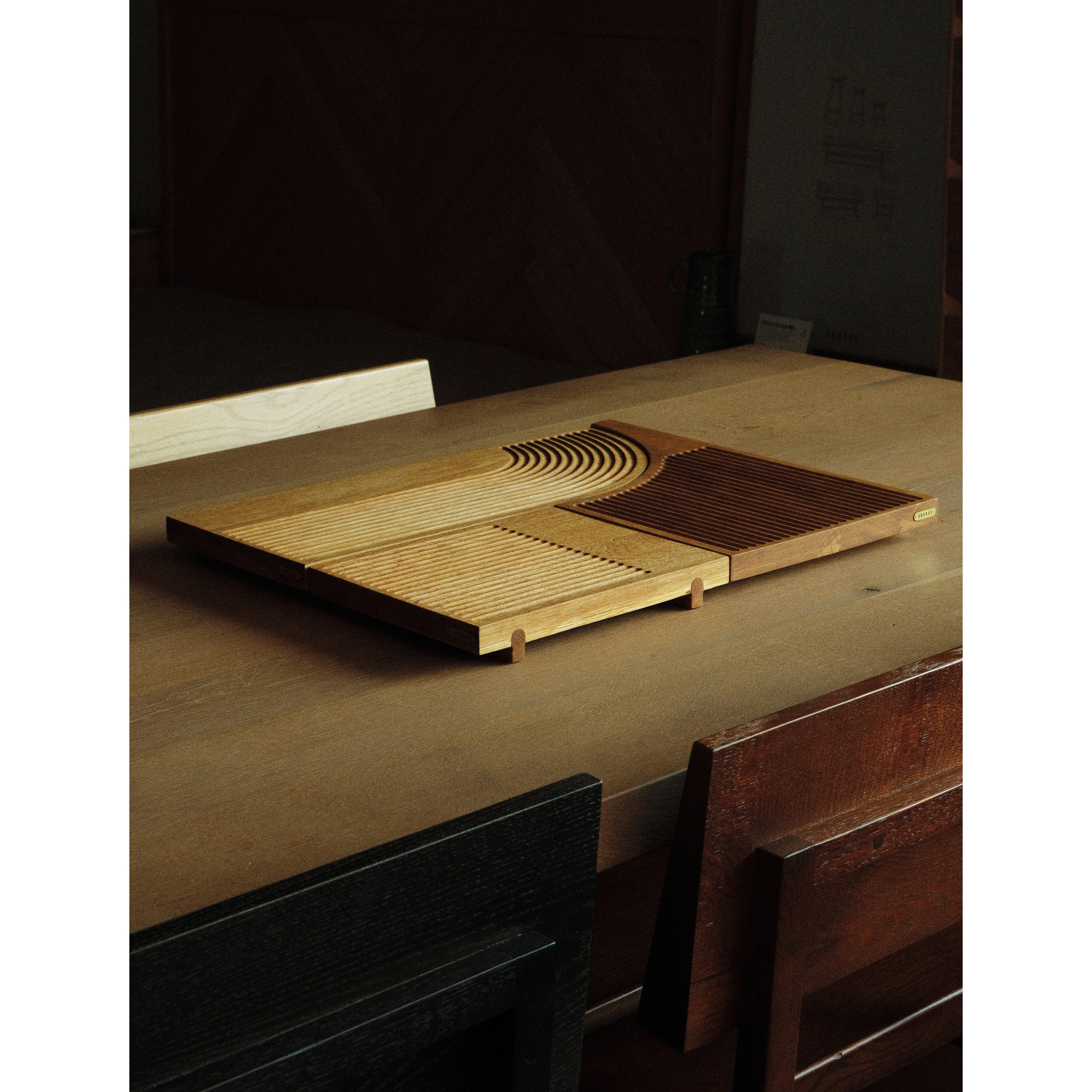 Ananas table set is made from solid oak wood all with precision and craftsmanship. The set includes three pieces of serving trays with different sizes and forms. With the arrangements of the channels on its surface, it prevents the liquid of food