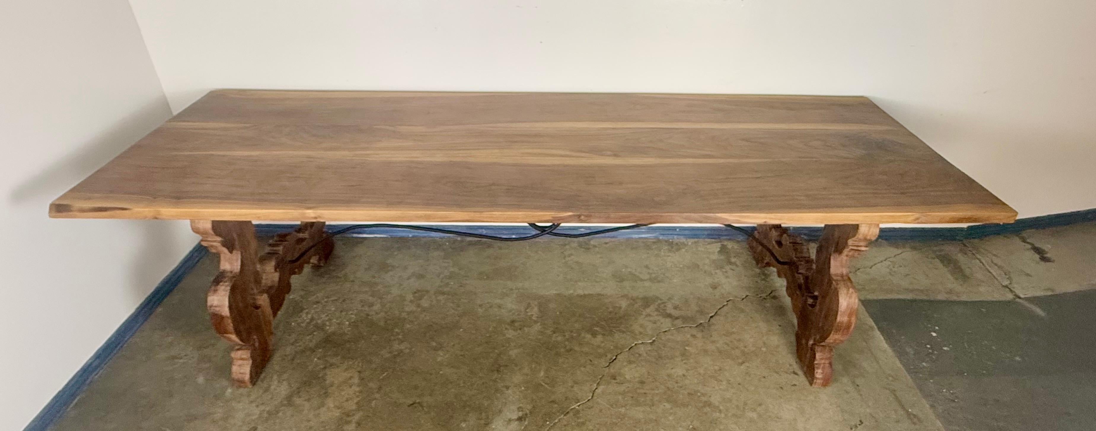 Une table de salle à manger en bois massif substantielle, fabriquée à la main, qui met en valeur la beauté naturelle et le mouvement du grain. Le large plateau met en valeur les variations organiques et la profondeur tonale du bois, fini dans un