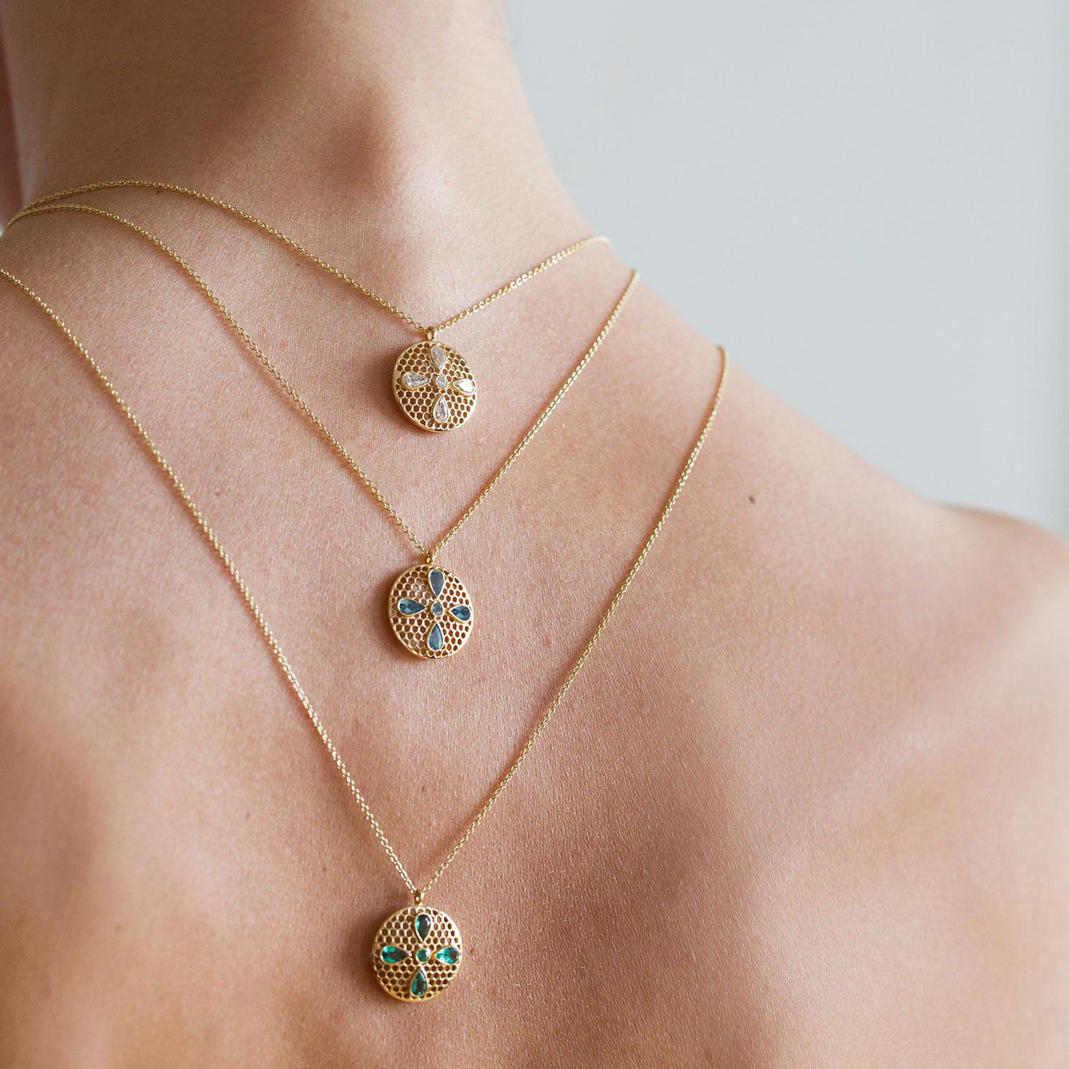 Handcrafted Spinel and 18 Karat Yellow Gold Pendant Necklace. Our bejewelled four leaf clover rests on our hand pierced gold lace as a symbol of eternal blessing. Can be worn both with a casual outfit for an every day look or with a more elegant