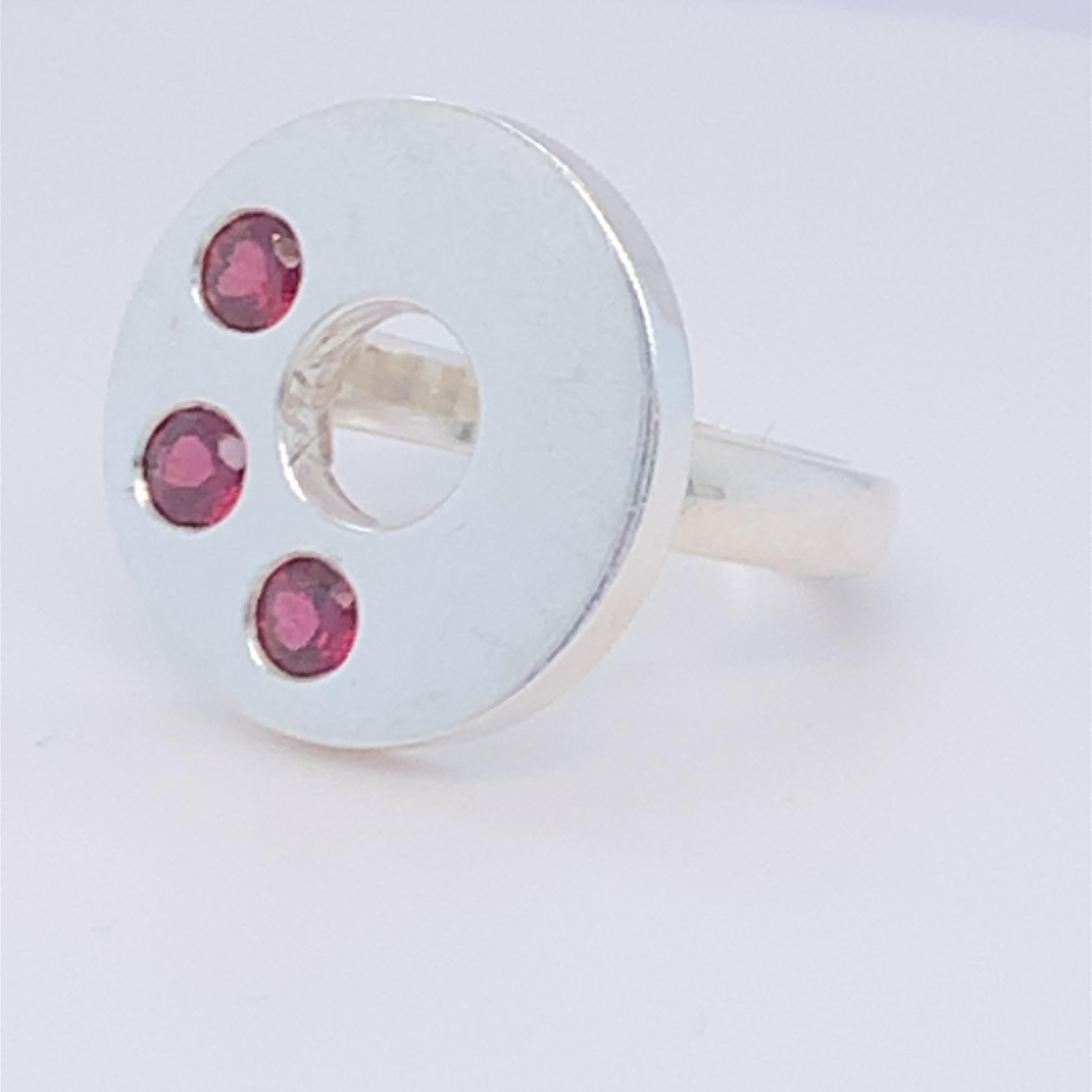 This magnificent disc design ring boasts three round garnets. Birth stone of the month of January. This elegant and stunning piece is suitable for day wear. Set in sterling silver and hand made by master craftsman.

Garnet: 0.50ct