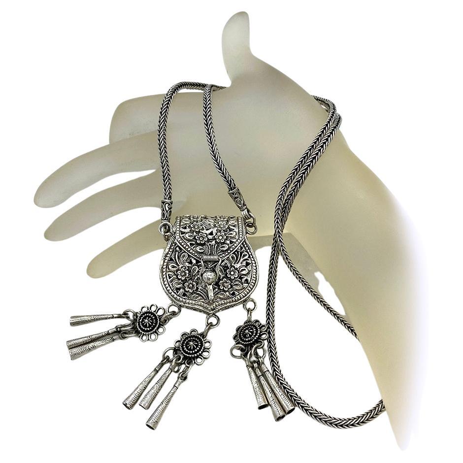 Questo è un ciondolo a forma di borsetta in argento sterling in stile Miao del Southeast Asia, realizzato a mano e appeso a una lunga collana. Il borsellino dettagliato e funzionale di 1,5 x 3,25 x 1 pollice con tre gruppi di frange pende da una