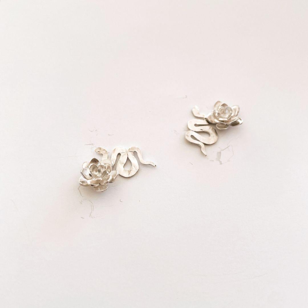 Meticulously handcrafted in 925 sterling silver, these Snake and Flower Earrings merge two powerful symbols: the snake, representing transformation and rebirth, and the flower, a timeless emblem of beauty and growth.

Their delicate design and