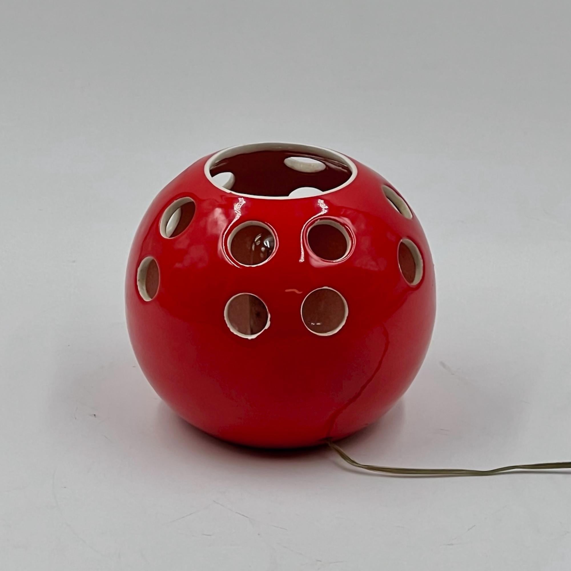 This 70s Ceramic Lamp attributable to Tarcisio Tosin exemplifies the craftsmanship and creativity of Italian design. Made from durable red ceramic, the lamp is a striking yet practical addition to any home or professional setting.

Its perforated