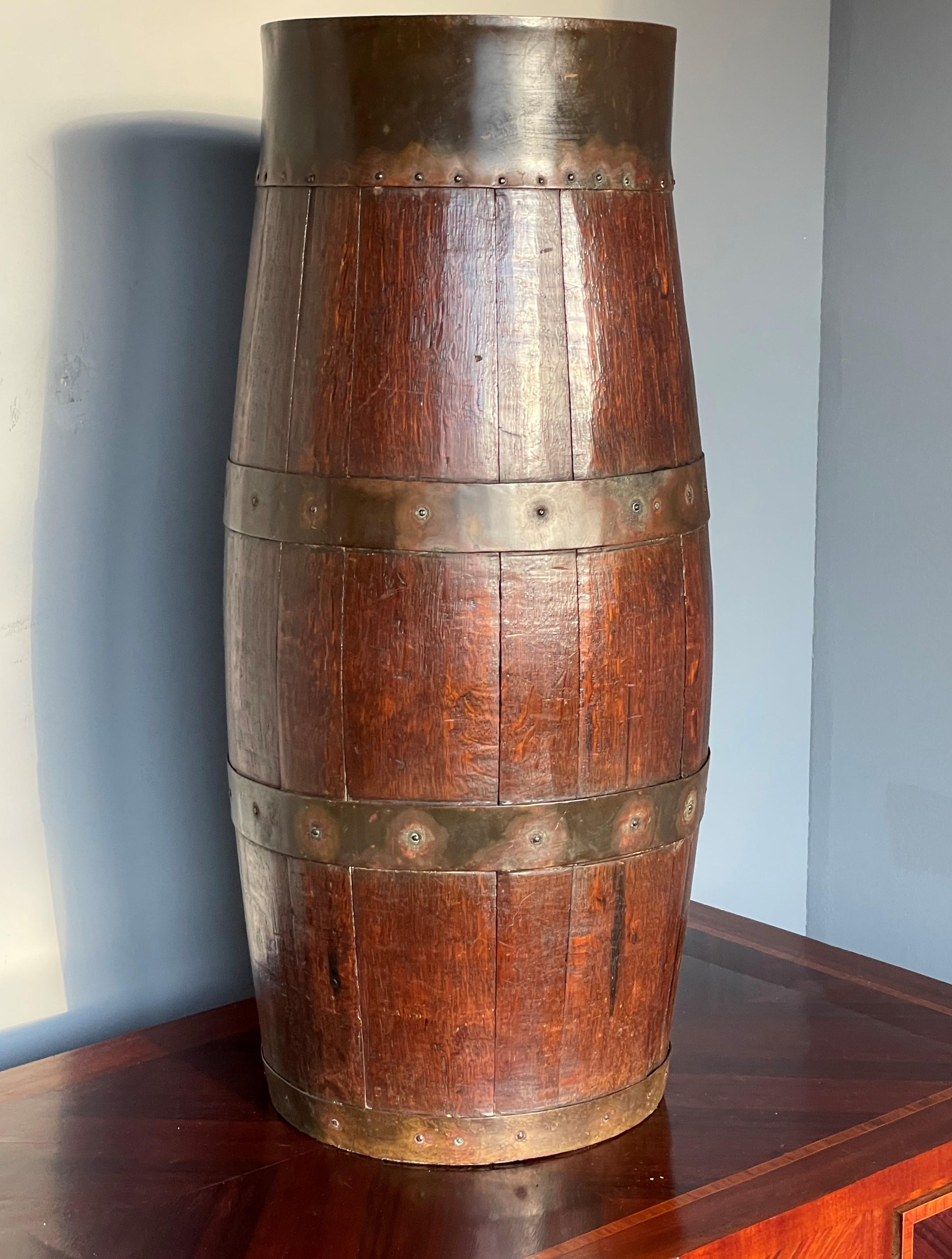 Great quality, condition and patina.

The condition of this handcrafted, barrel shaped umbrella or stick stand is right up there with the best. It is made of solid, stained tiger oak only and the curved oak parts that together make the barrel are