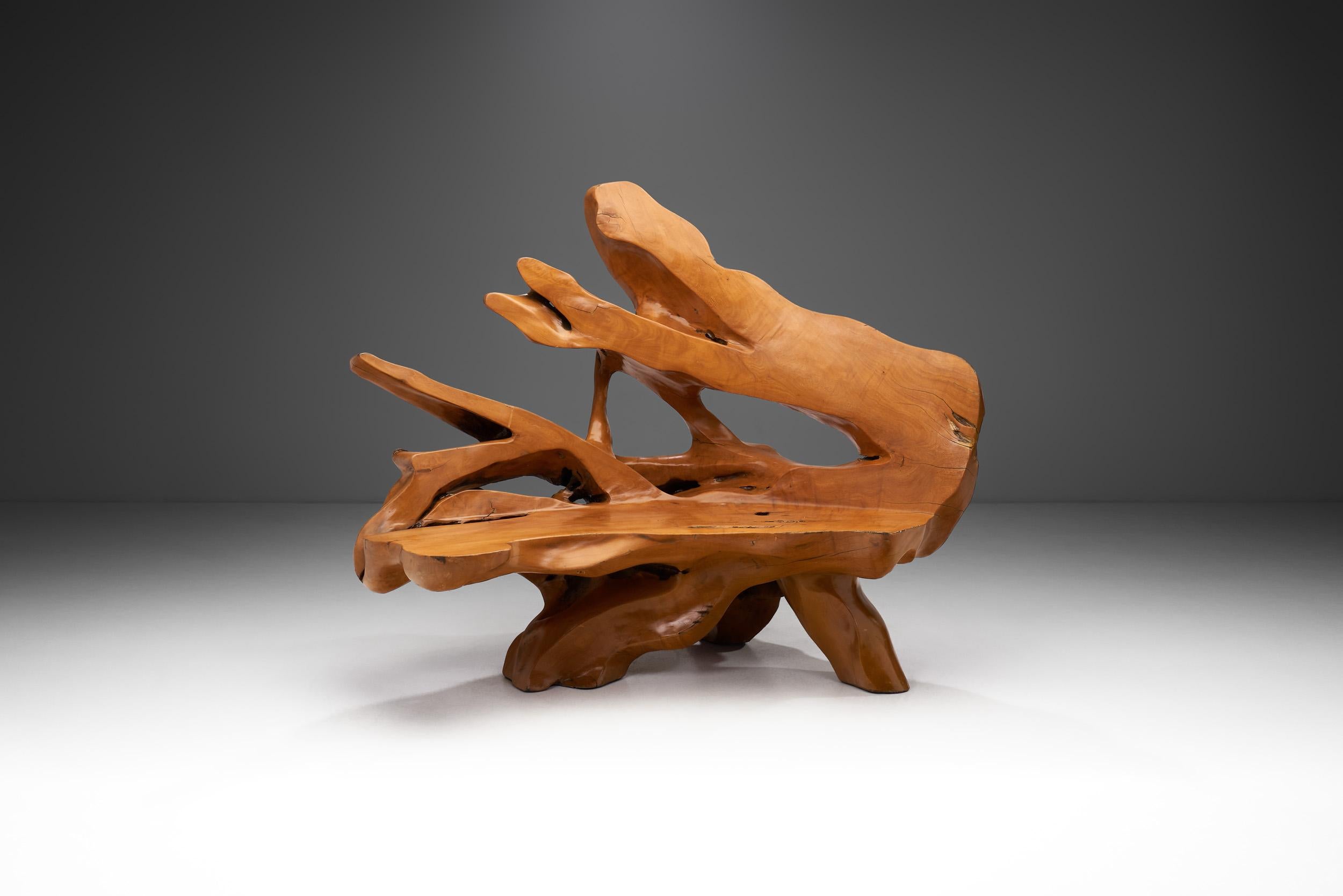 Inspiré par la beauté de la forme naturelle des racines, ce banc en teck organique est fabriqué à la main à partir d'un seul morceau de racine de teck. La racine est minutieusement déterrée. La surface est poncée et polie tout en préservant les