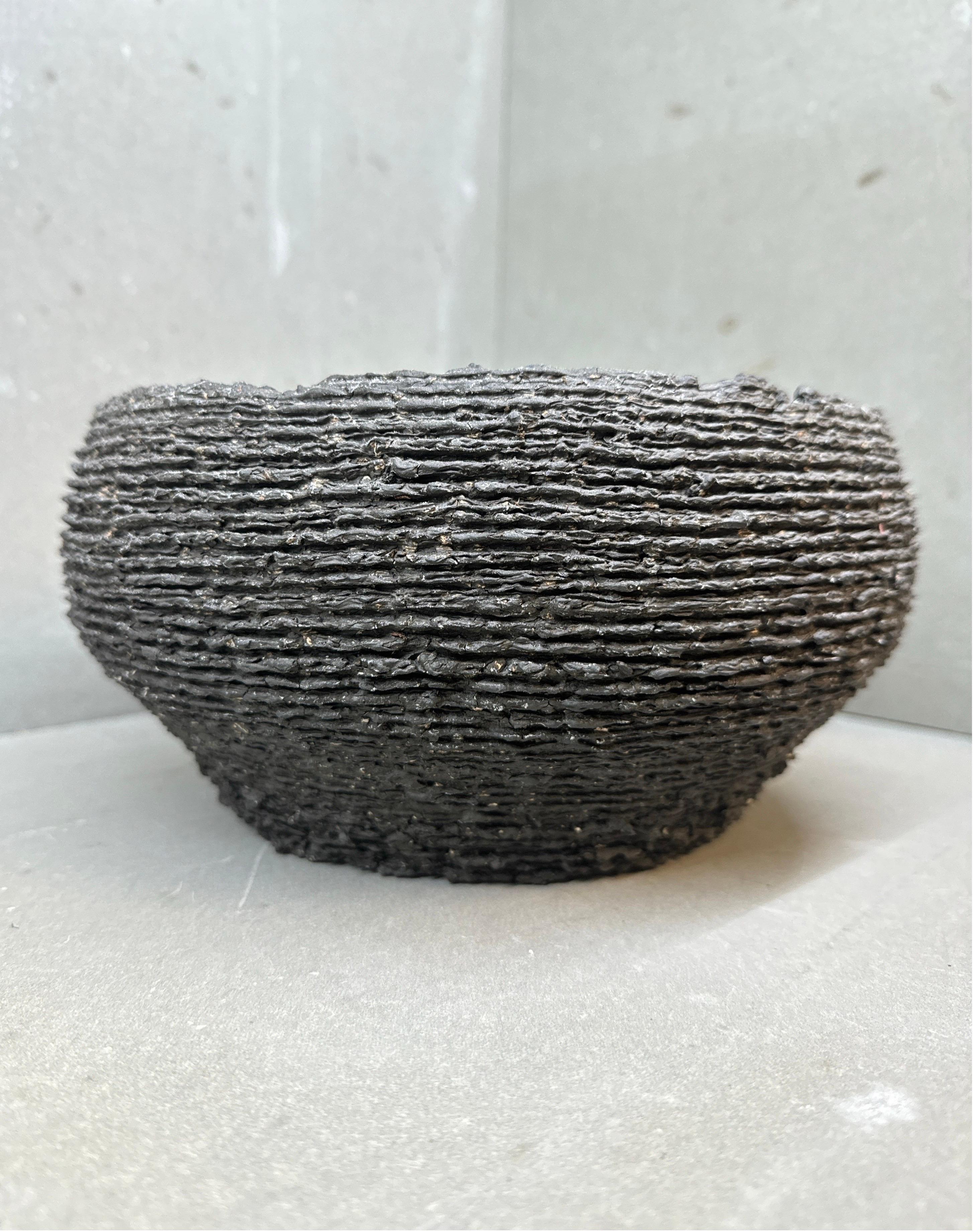 Questo vaso scultoreo in ceramica presenta un esterno meticolosamente costruito a mano e stratificato che evoca la forza tranquilla delle formazioni geologiche o della corteccia fossilizzata. Realizzato con materiali sostenibili e cotto con metodi