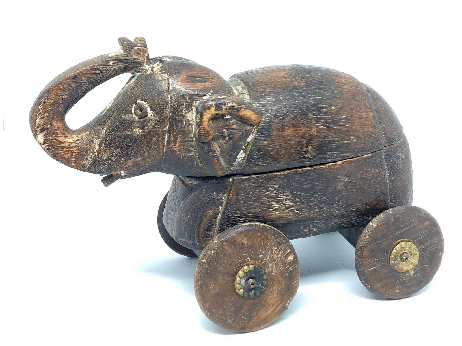 Sculpture rustique d'un éléphant, probablement utilisée comme jouet à tirer ou simplement comme objet d'exposition avec une chambre secrète. Usure importante avec quelques pertes. Une pièce rustique et excentrique pleine de charme. Nous pensons