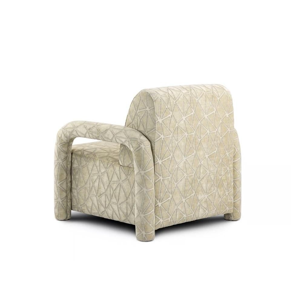 Ce fauteuil contemporain est une étude de lignes gracieuses et de design réfléchi. Il est doté d'une assise et d'un dossier rembourrés et moelleux, offrant un espace de détente confortable et accueillant. L'élément le plus distinctif est l'élégance