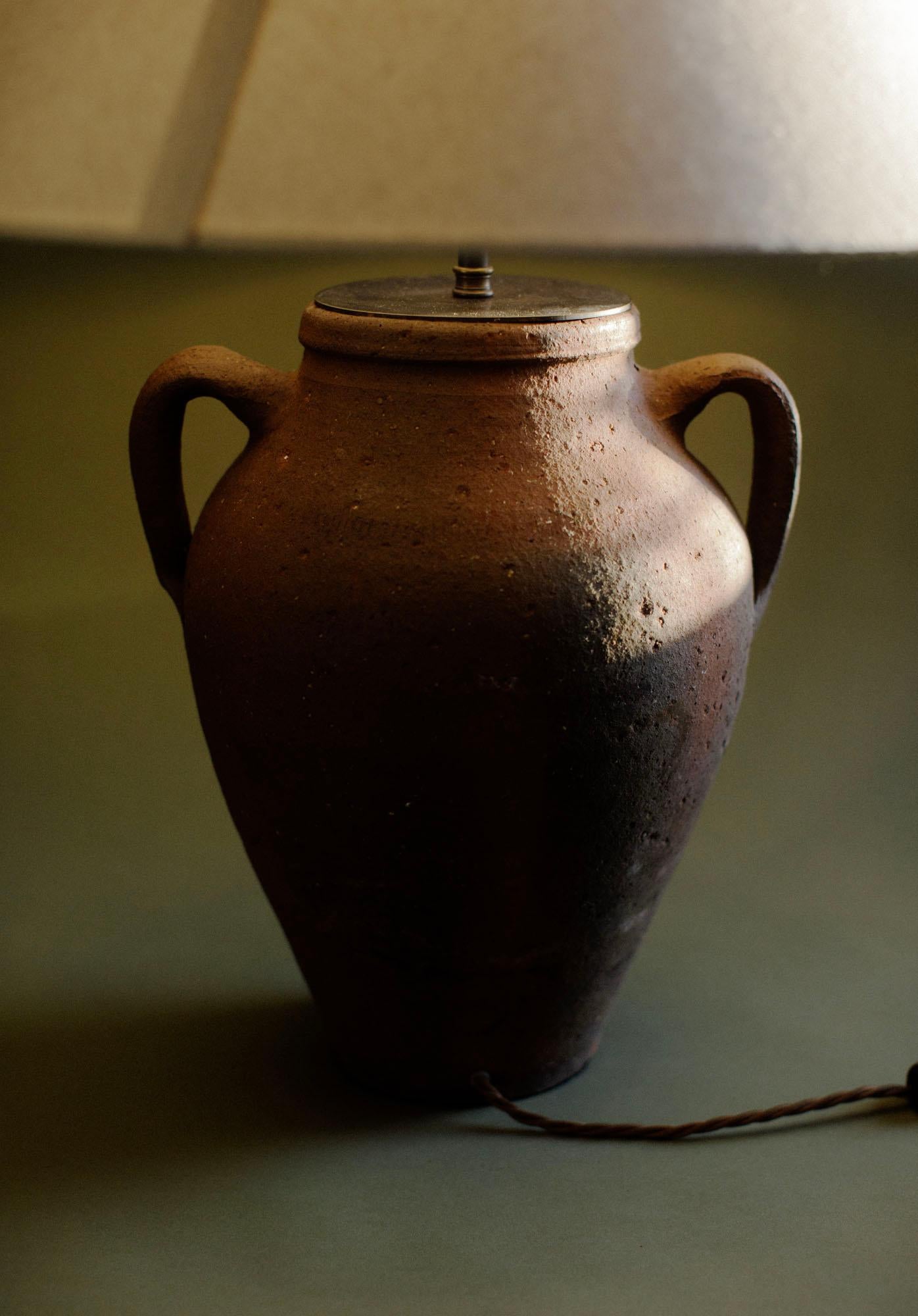 Lampe de table vintage en terre cuite turque, fabriquée à la main au 20e siècle selon les techniques traditionnelles de la poterie anatolienne. La lampe est fabriquée en terre cuite naturelle et présente des marques de surface et une usure