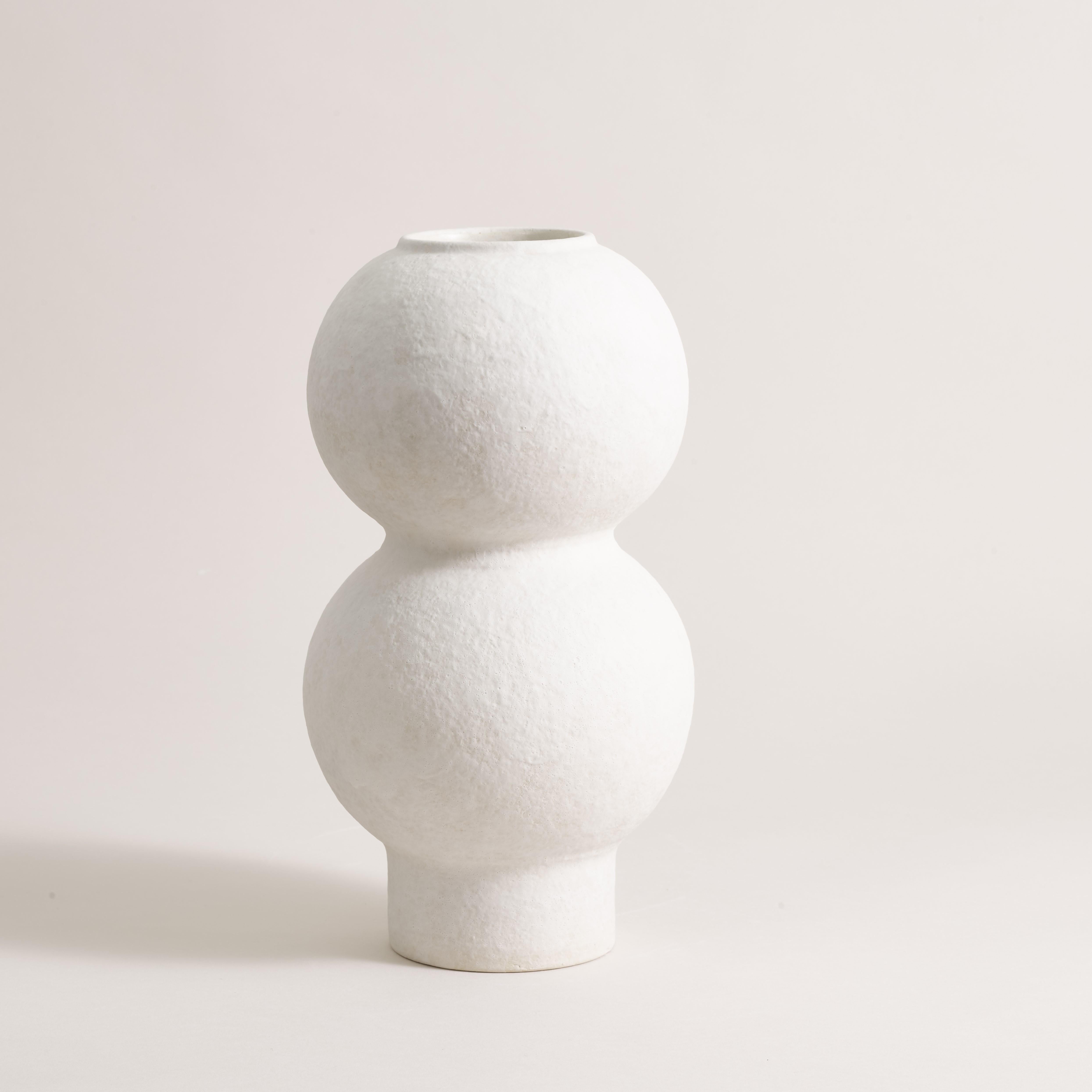 Handcrafted Vase 075 by Lovebuch.
Dimensions: Ø 15 x H 28 cm.
Materials: Sandstone, porcelain, handcrafted piece.

Katia works with wood and clay, these raw, powerfully expressive materials are shaped to create a poetry of objects that inhabit