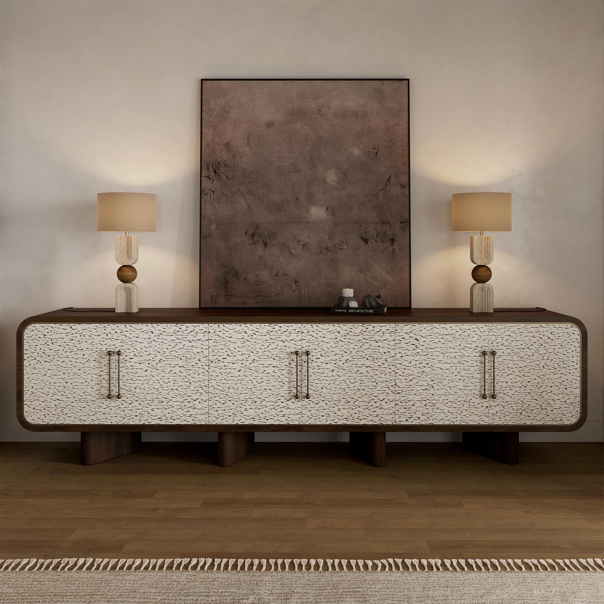 The Viti Sideboard by Nolita Harbour exudes elegance and craftsmanship, combining the richness of walnut wood with a refined, textured veneer on its doors. This unique piece rests on three sturdy legs, creating a balanced and modern silhouette. With