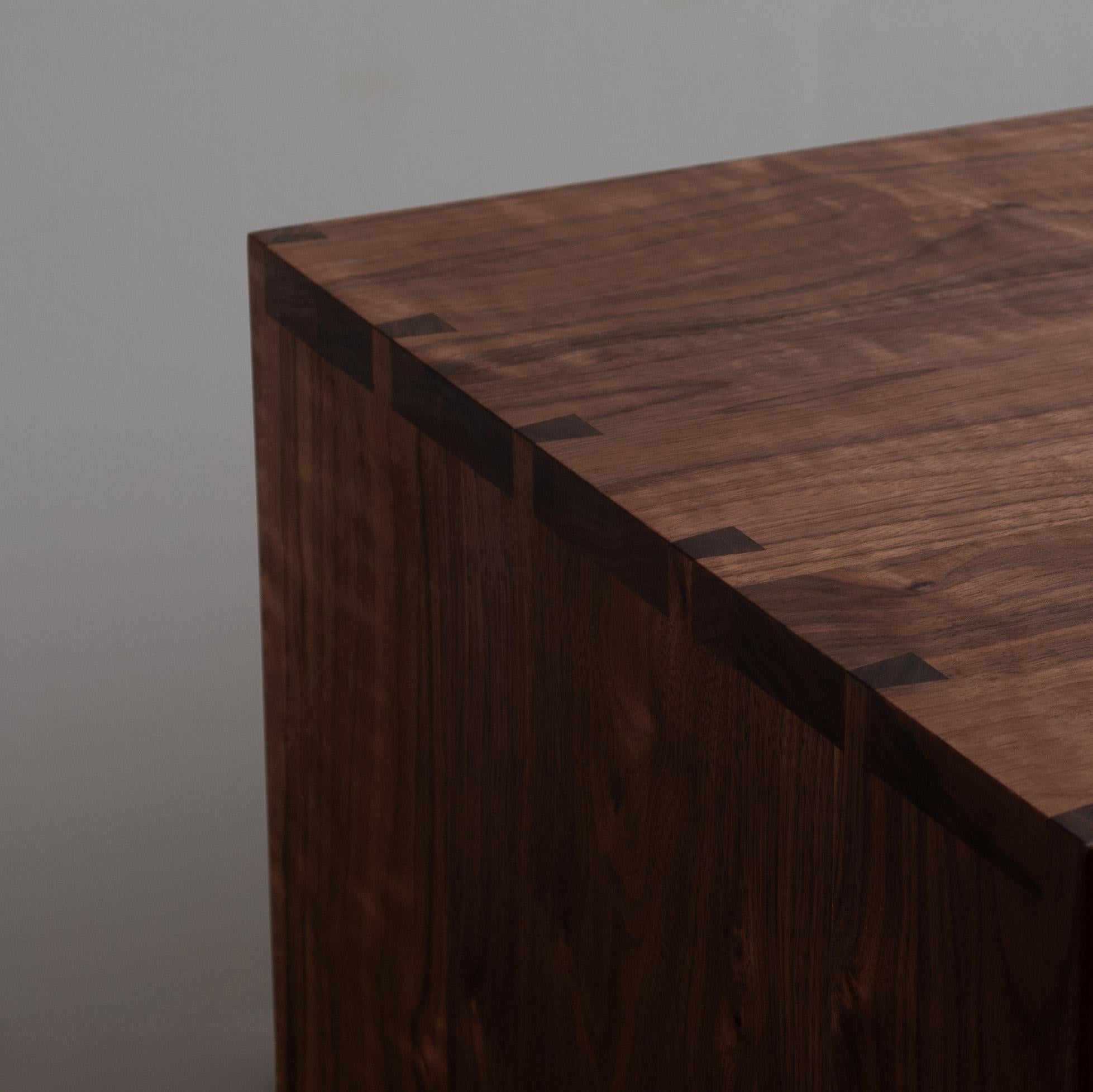 Our handcrafted AMC sideboard credenza with visible hand-cut dovetail jointing to main surfaces. Two soft close drawers with internal oak carcasses and two cupboards below with internal shelves. 
We carefully select the walnut so that it flows