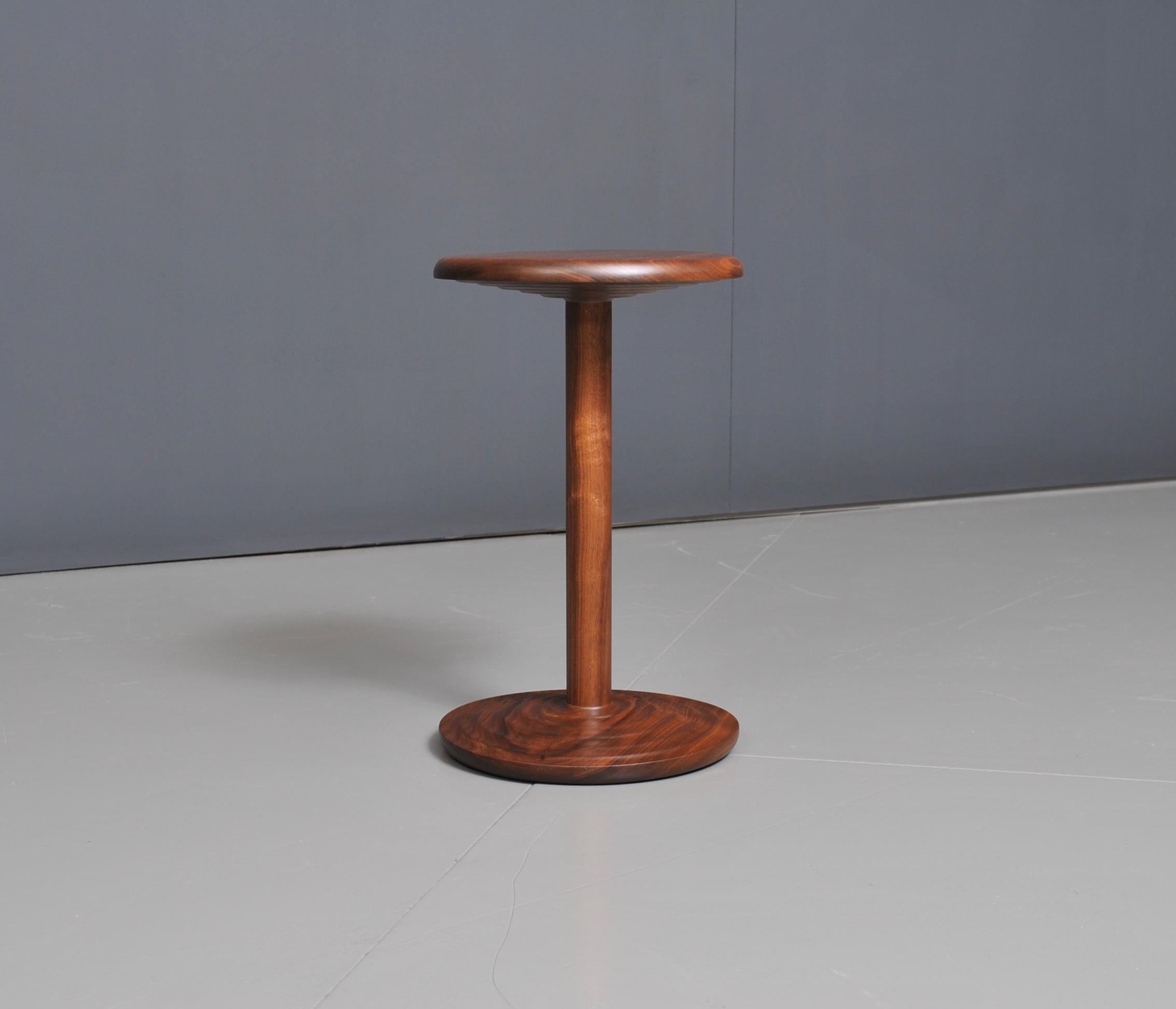 Beautifully turned and handcrafted walnut side table in modernist midcentury design. Perfect in form and scale. This is a bespoke piece of the fine quality, handmade by master-craftsman in the UK using American black walnut. Hand finished with water