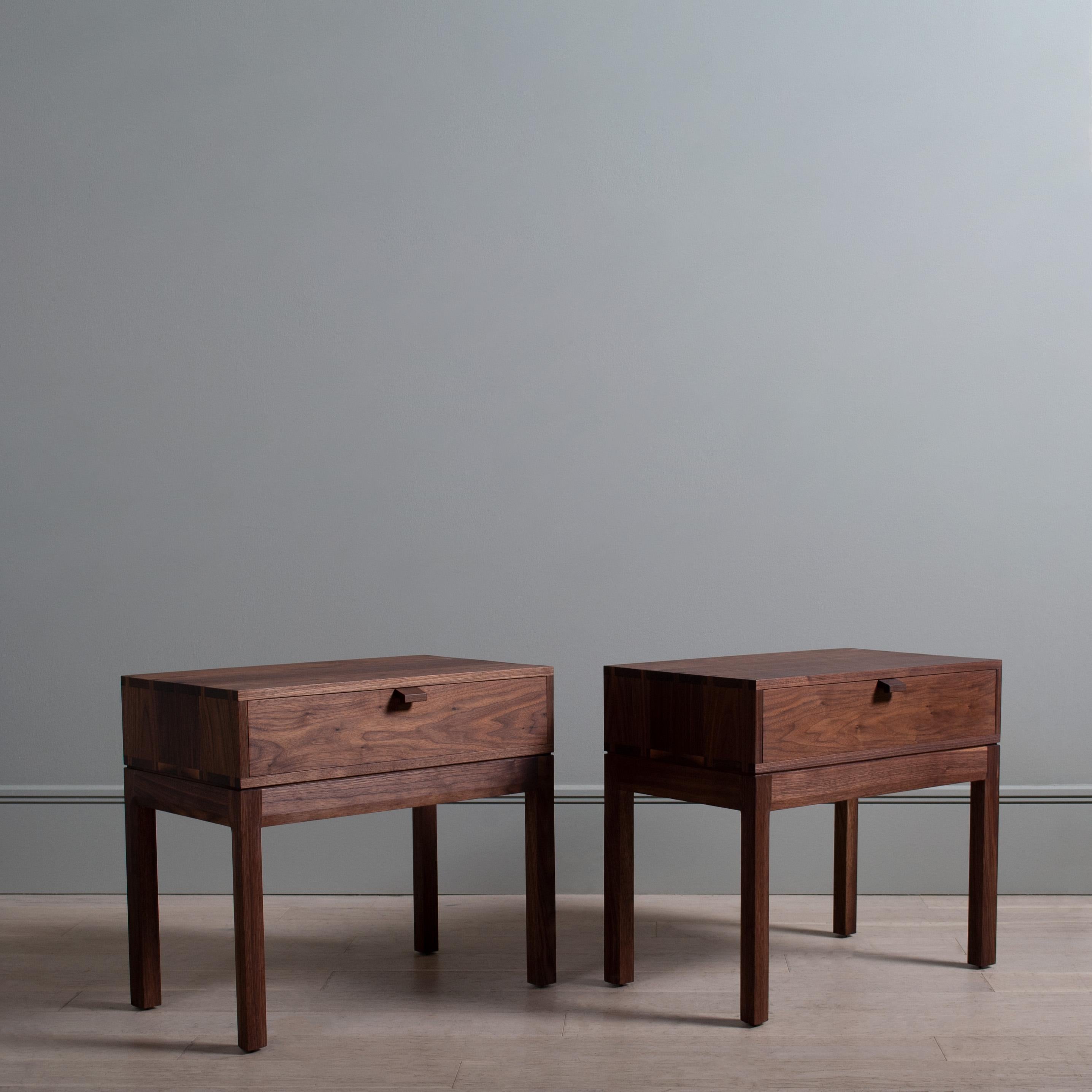 A pair of black walnut hand-crafted nightstands, or end tables, in the midcentury modernist style. Constructed from finest American black walnut with the inner dovetailed jointed drawer carcass in English Quartersawn Oak. The upper box is detailed