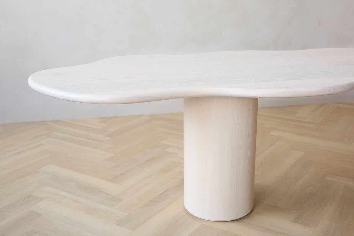 Entdecken Sie die Eleganz und Sanftheit unseres Cloud Dining Table. Die organische Form und die abgerundeten Kanten dieses Tisches sorgen für ein angenehmes und taktiles Erlebnis beim Sitzen am Tisch. Die einzigartige, wolkenähnliche Form des Stücks