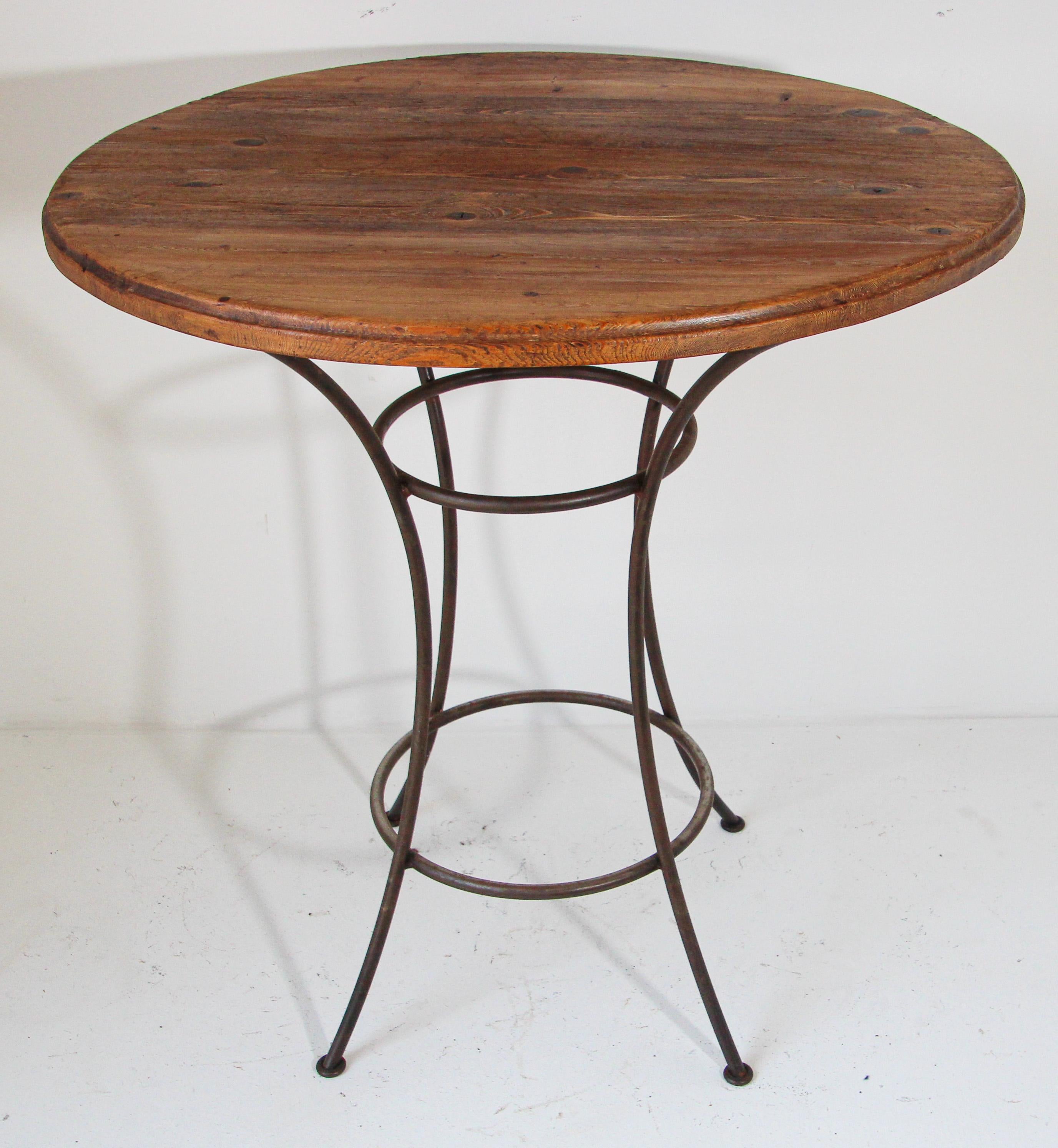 Handcrafted custom bar height table with wrought iron forged base and 39.5 inches diameter wood round top.
Spanish Revival bar table with beautiful wood round top and four curved simple legs. 
Dimensions:
Overall: Diameter 39.5