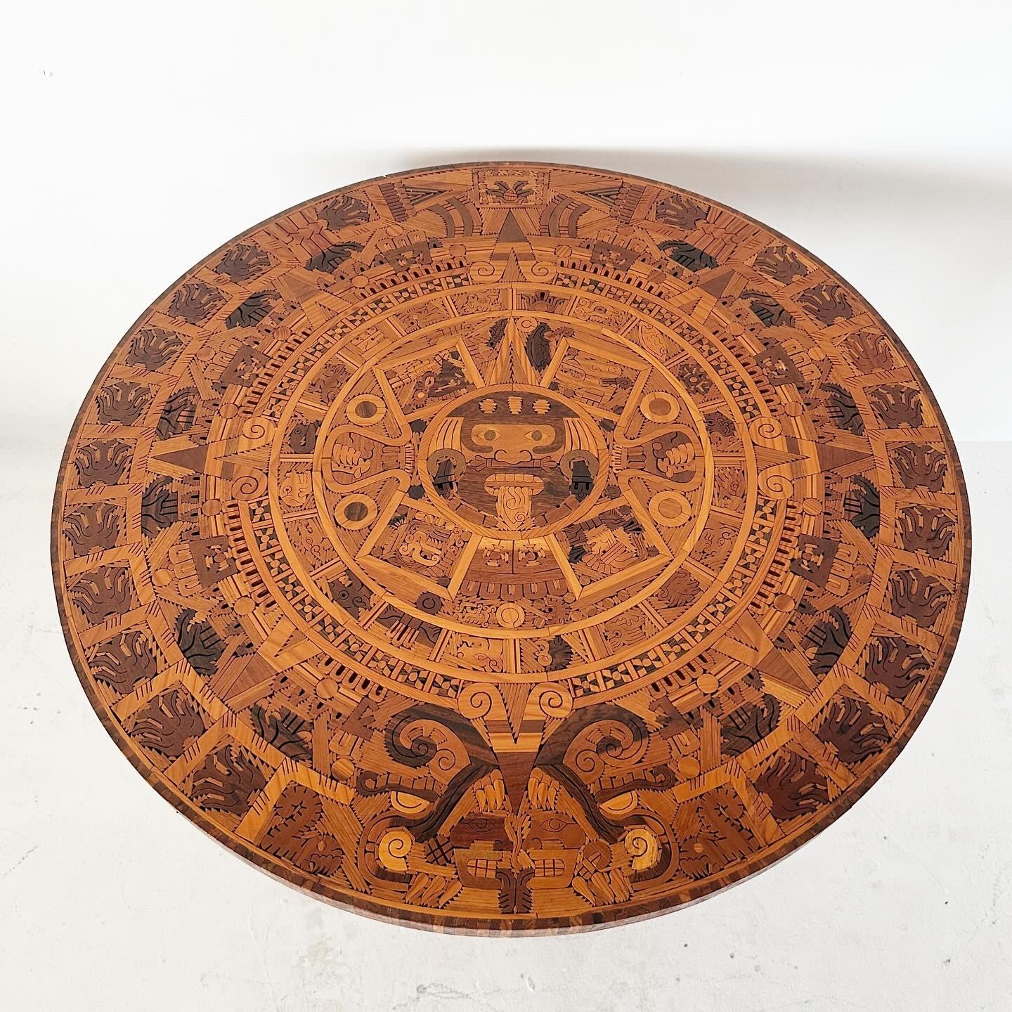 Handcrafted round wooden inlay Aztec calendar dining table. Incredible detail, good vintage condition. Circular top separates from solid wood base for easy transport.

H28.5 Diameter 40.5 (seat height)