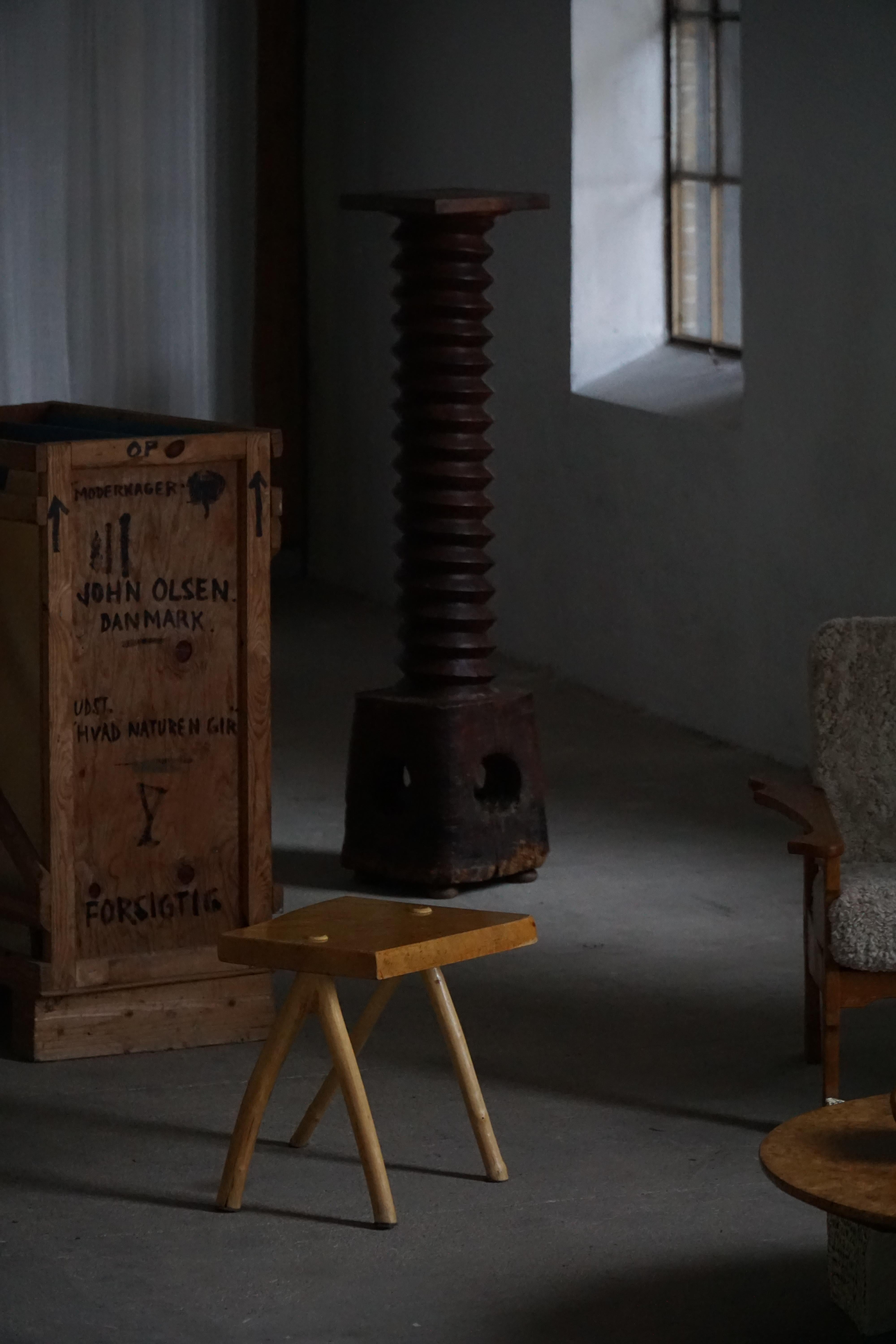 Tabouret sculptural en bouleau fabriqué à la main, doté d'une assise rectangulaire de belle forme et de quatre pieds à la courbure organique. La pièce présente une patine chaude aux tons de miel et des veines de bois visibles qui mettent en valeur