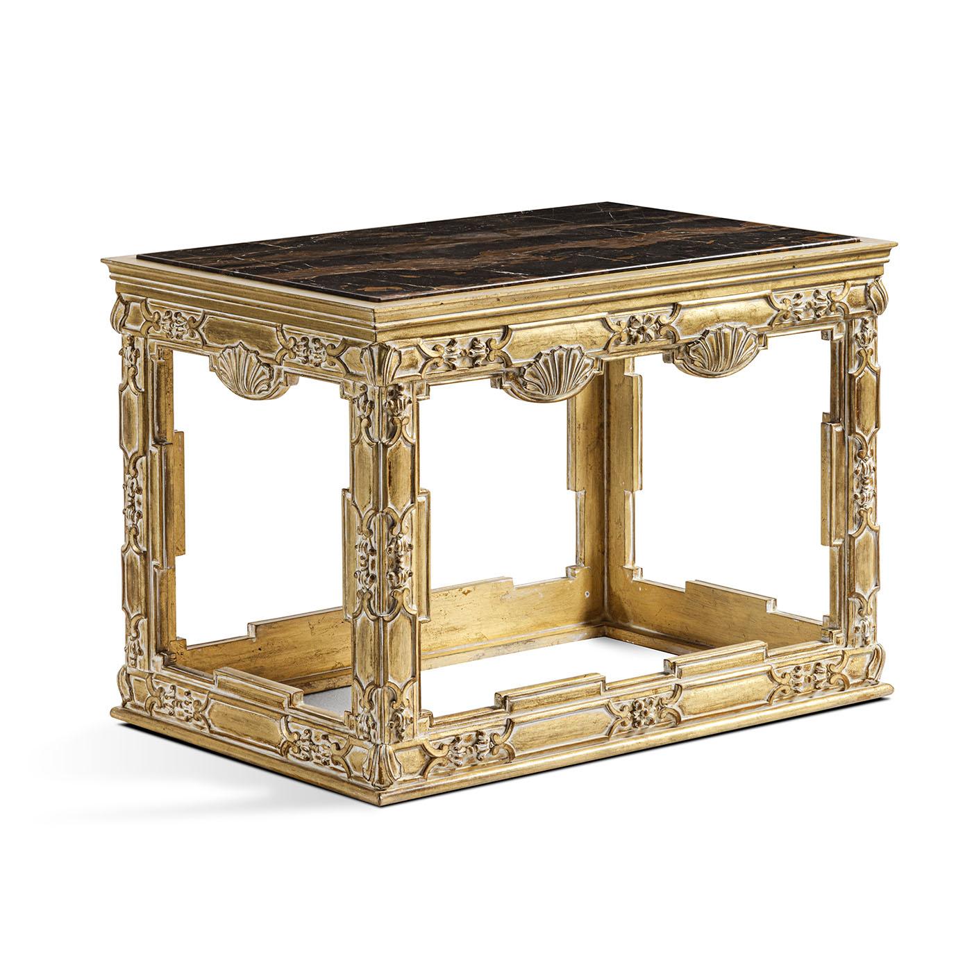 Charming wood side table adorned with hand-carved details. The piece is completed with an elegant marble top.
