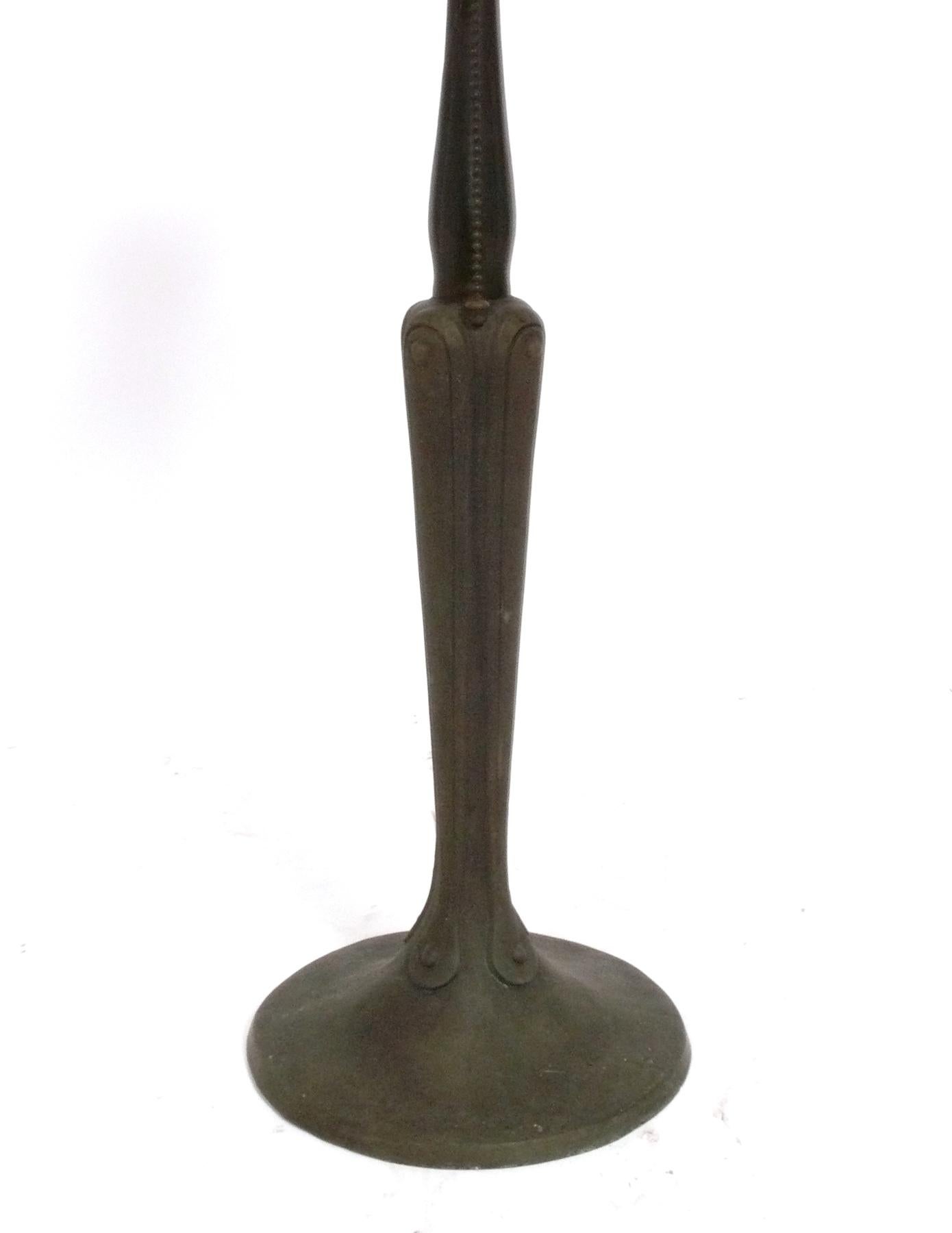 Arts & Crafts era bronze lamp with mica shade, made by the Handel Company, unsigned, American, circa 1910s. This lamp looks wonderful when it is lit, as the mica shade gives off a warm glow. It has been rewired with a brown cloth cord and is ready