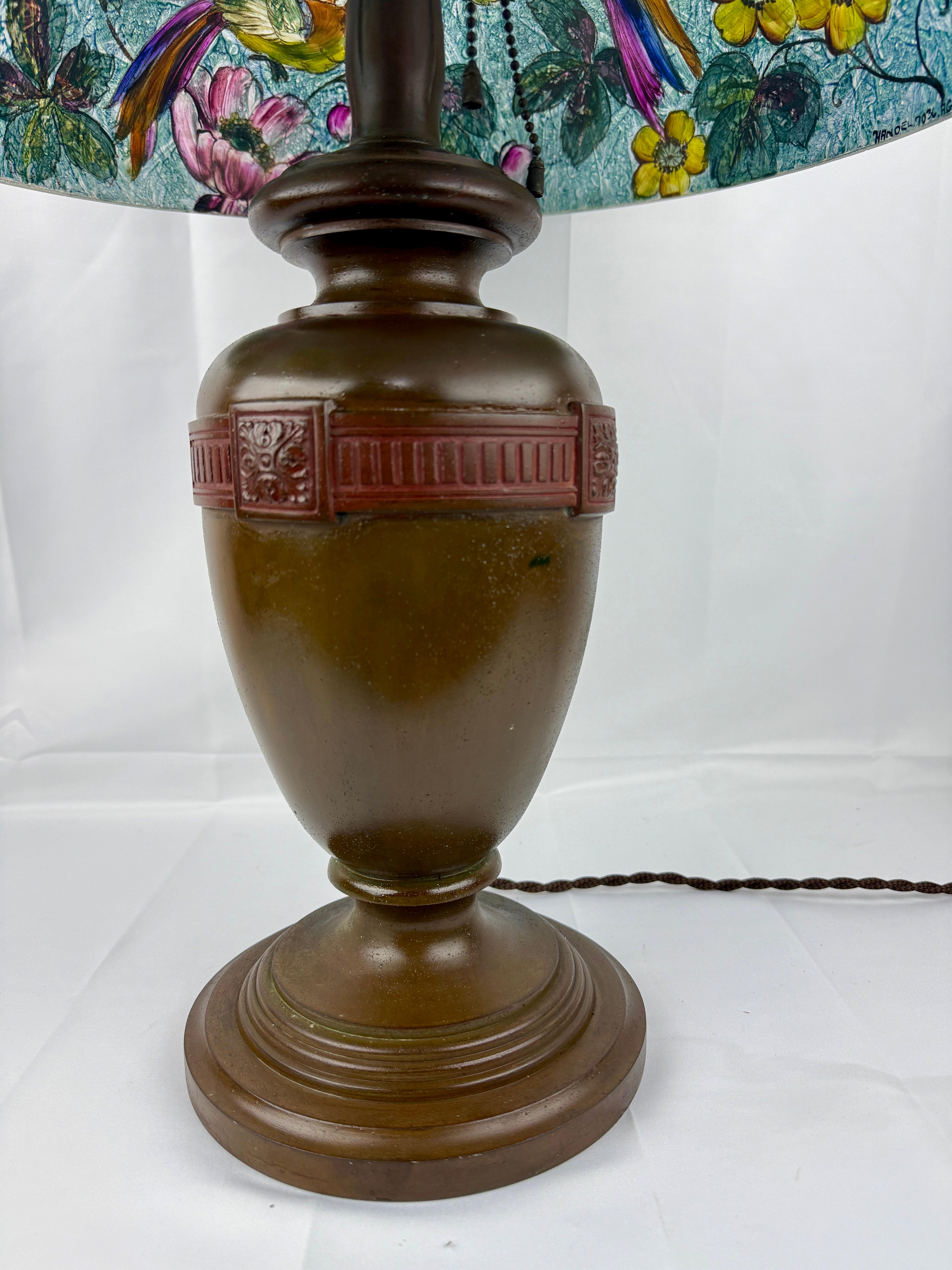 Handel (American, 1885 - 1936), circa 1915. 

This exceptional table lamp exemplifies the artistry and craftsmanship of the Handel Company, featuring a reverse-painted glass shade on a chipped ice design, signed 