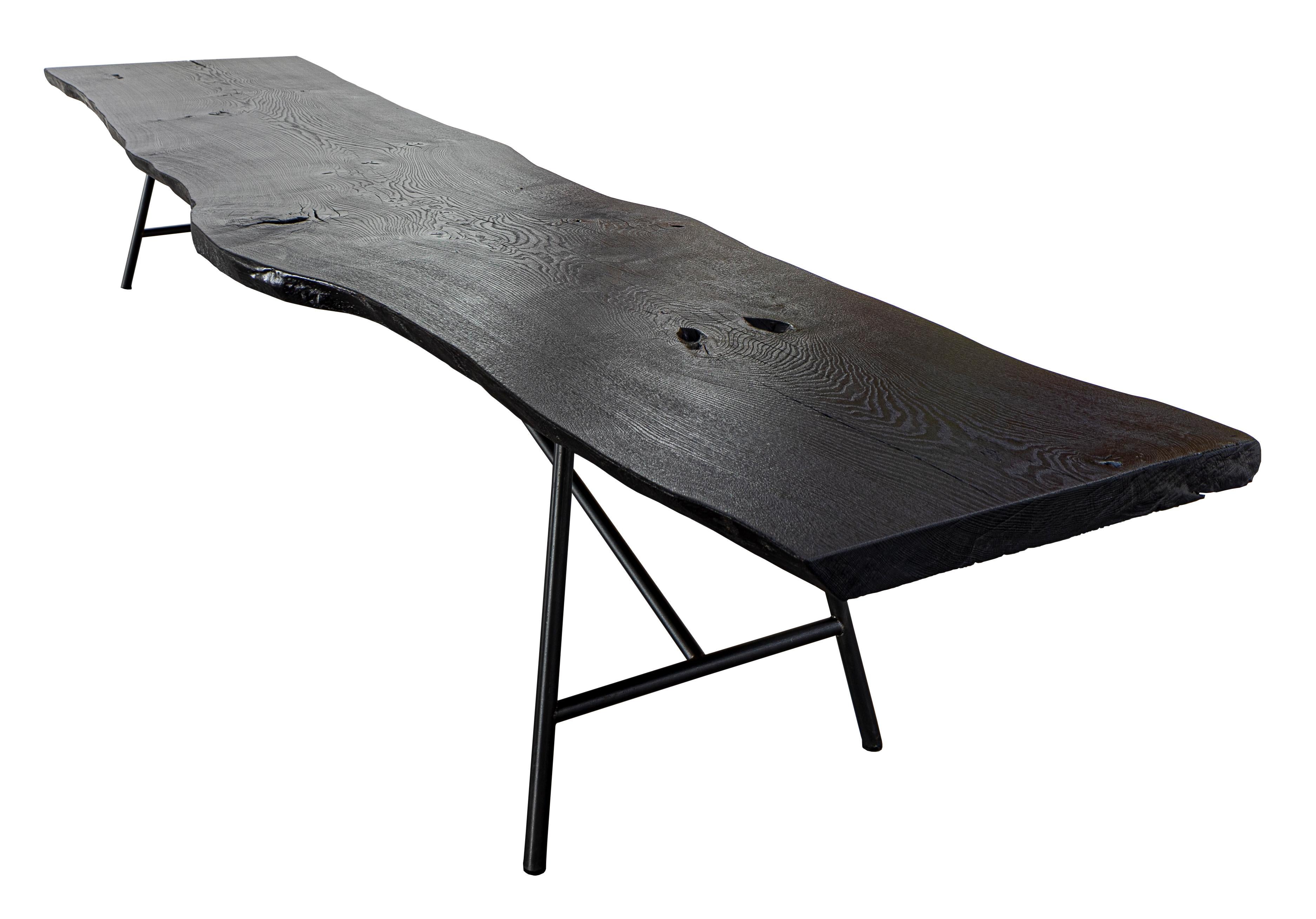 Cette table en Unikat avec un revêtement de sol léché peut être remplacée en un seul bloc par une table en bois de chêne. La combinaison d'une terre noire, façonnée par le feu selon une tradition vieille de plus d'un siècle, et d'une pierre taillée