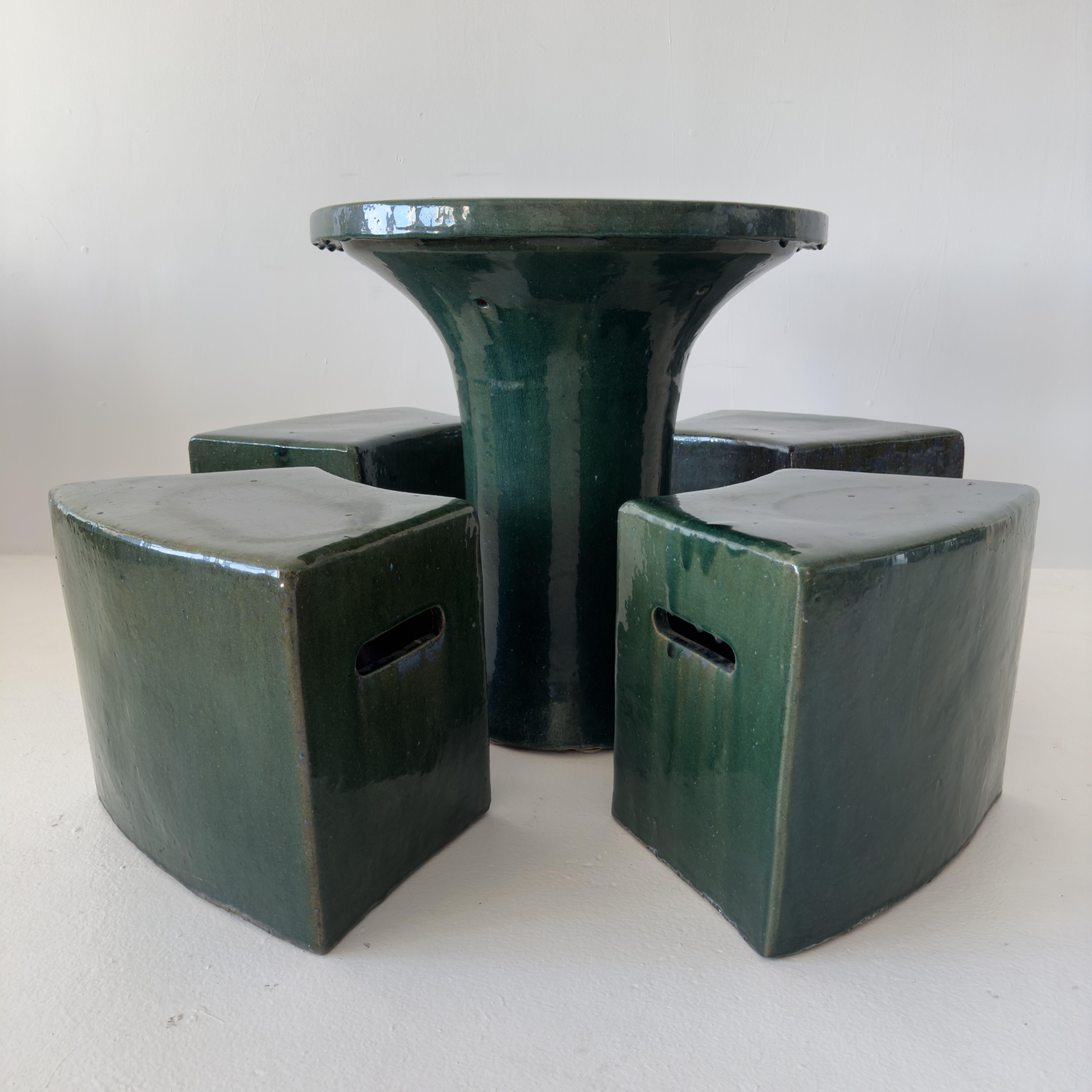 Table à thé / table de jardin en céramique émeraude émaillée à la main avec quatre tabourets assortis. Usure correspondant à l'âge, y compris une belle patine et des craquelures. Quelques légères imperfections, la glaçure est lustrée et belle, avec