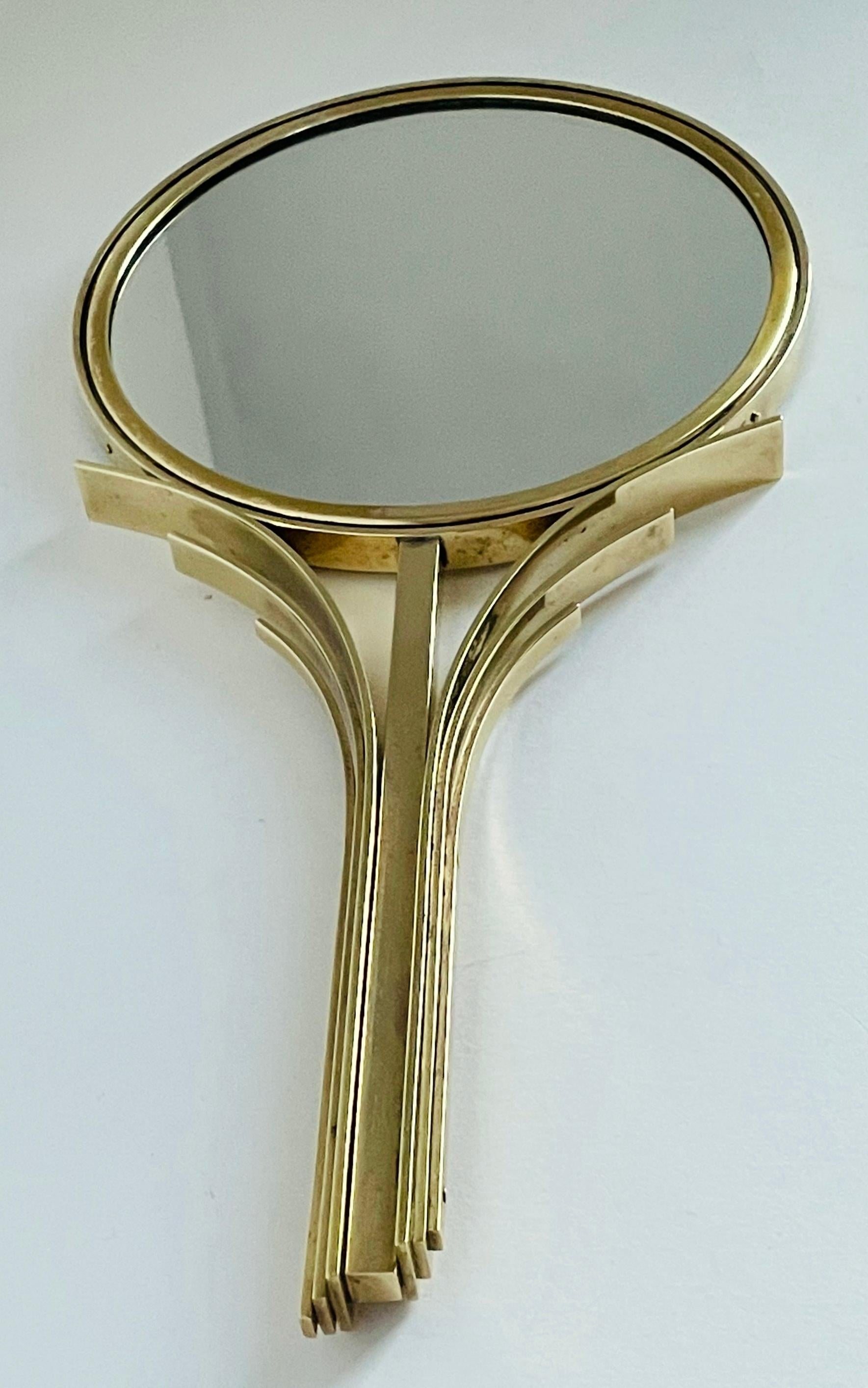 Rare miroir à main Art déco en laiton massif conçu par Ivar Ålenius Björk et produit par Ystad-Metall, Suède, dans les années 1930. 
Dimensions : largeur 16 cm, hauteur 32 cm.

