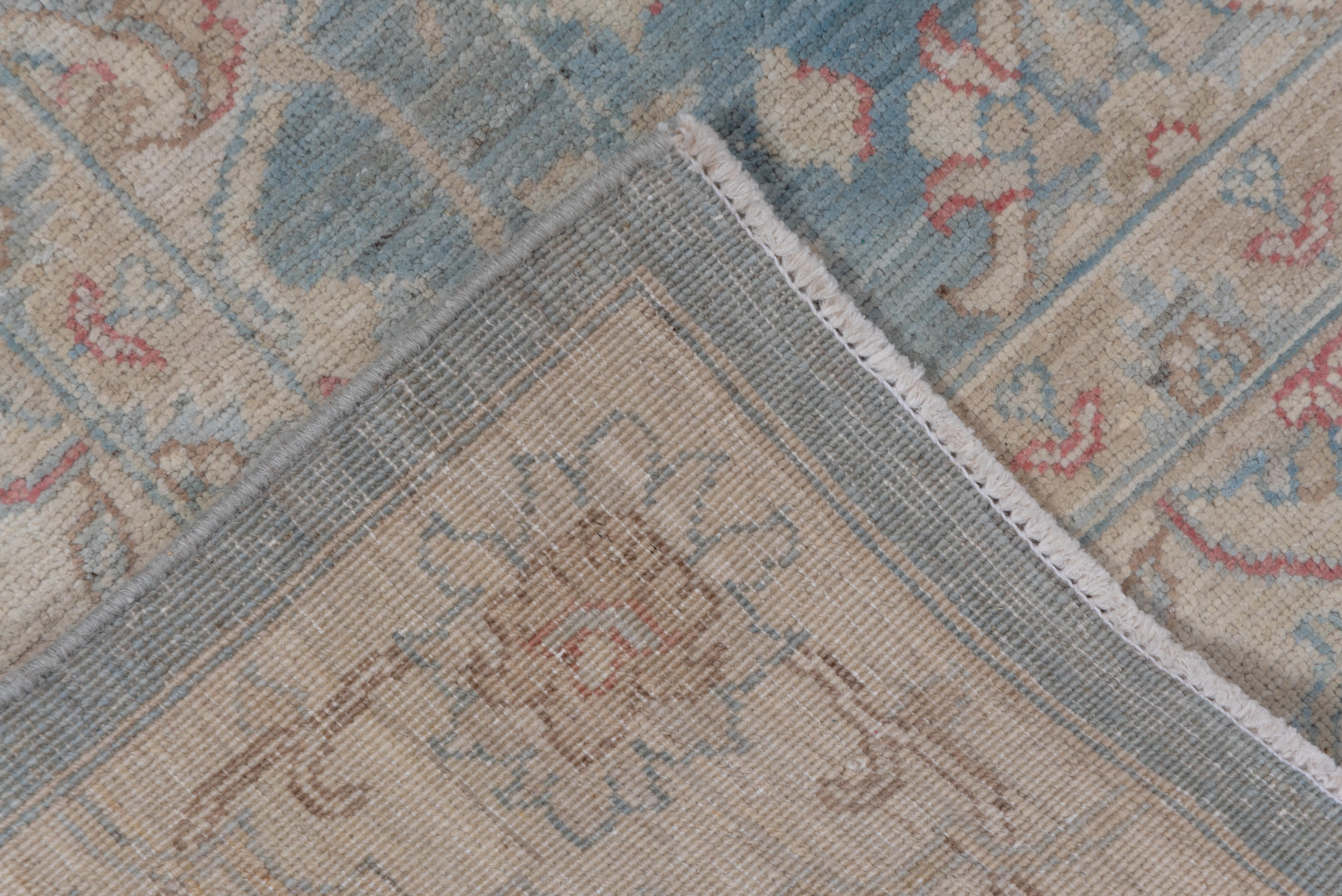 The light blue field displays an allover pattern of connected circles and ellipses in the west Persian Mahal manner, with cartouche-rosettes and clusters of small ecru flowers filling in. The creamy beige border features complete flowers and