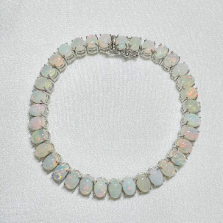 Das handgefertigte 16,45 Karat Feueropal-Tennisarmband aus Sterlingsilber präsentiert einen unendlich funkelnden natürlichen Opal mit einem Gewicht von 16,45 Karat. Es misst 7.25 Zoll in der Länge. 
Opal fördert die Konzentration und baut Stress ab.
