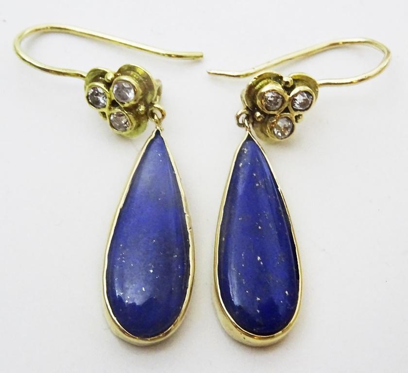  From our Jerusalem workshop, 
Handcrafted in acid tested 18 karat Gold.
The top portion is a clover of 3 diamonds size 2 mm round. Total Diamond weight 20 points
The bottom part is a 8 x 24 mm Pear Shaped Lapis Lazuli.
There is a safe hook