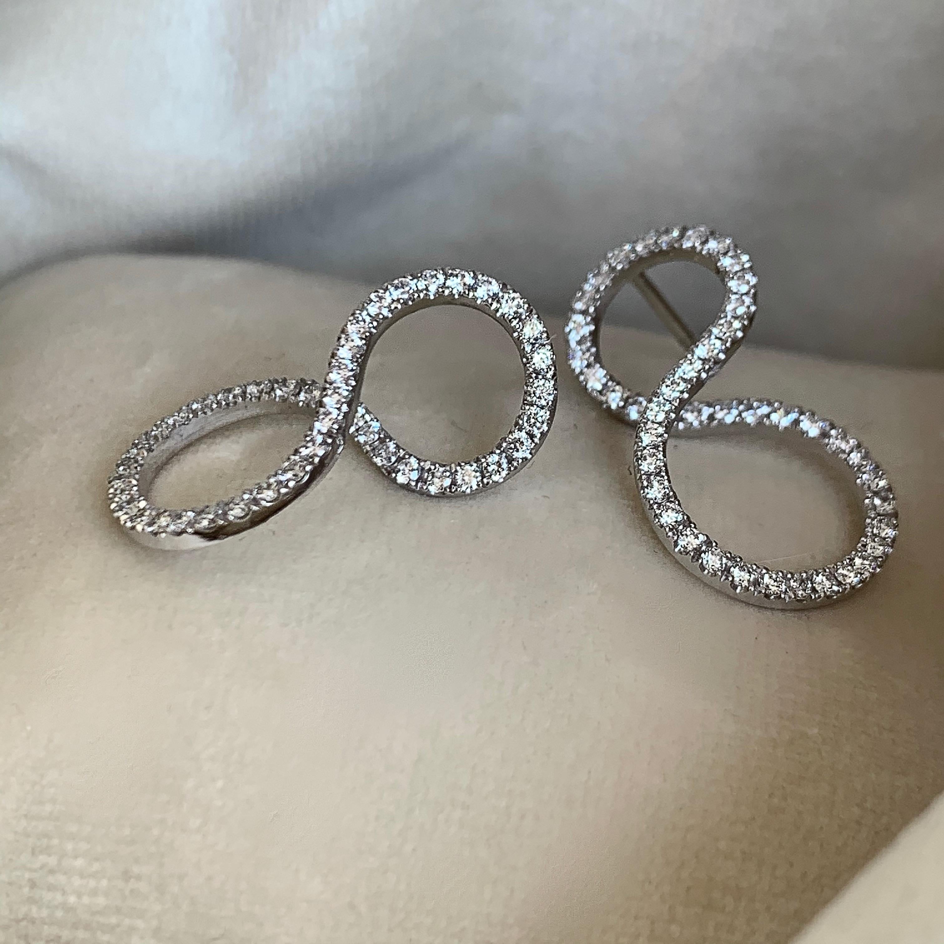 Earrings handmade in Belgium, in 18K white gold 4,6 g. Pave set with DGVS diamonds 0,90ct. The earrings can be worn in 2 ways, by changing the ear you get a different look. This exquisite product comes from Joke Quick, a jewellery designer and