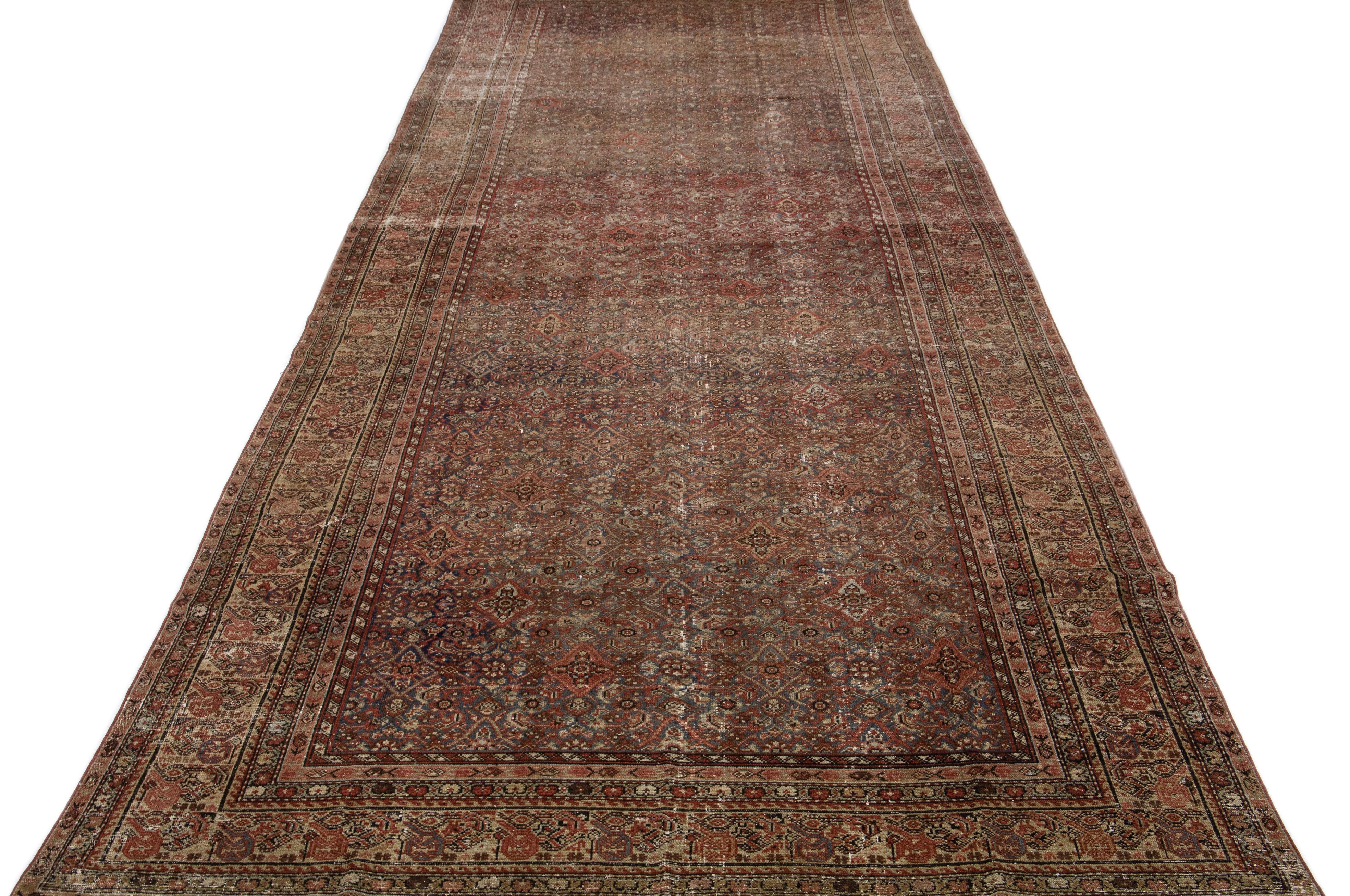 Beautiful antique Malayer hand-knotted wool rug with a blue color field. This Persian rug has rust accents in a gorgeous traditional allover floral design.

This rug measures 7'1