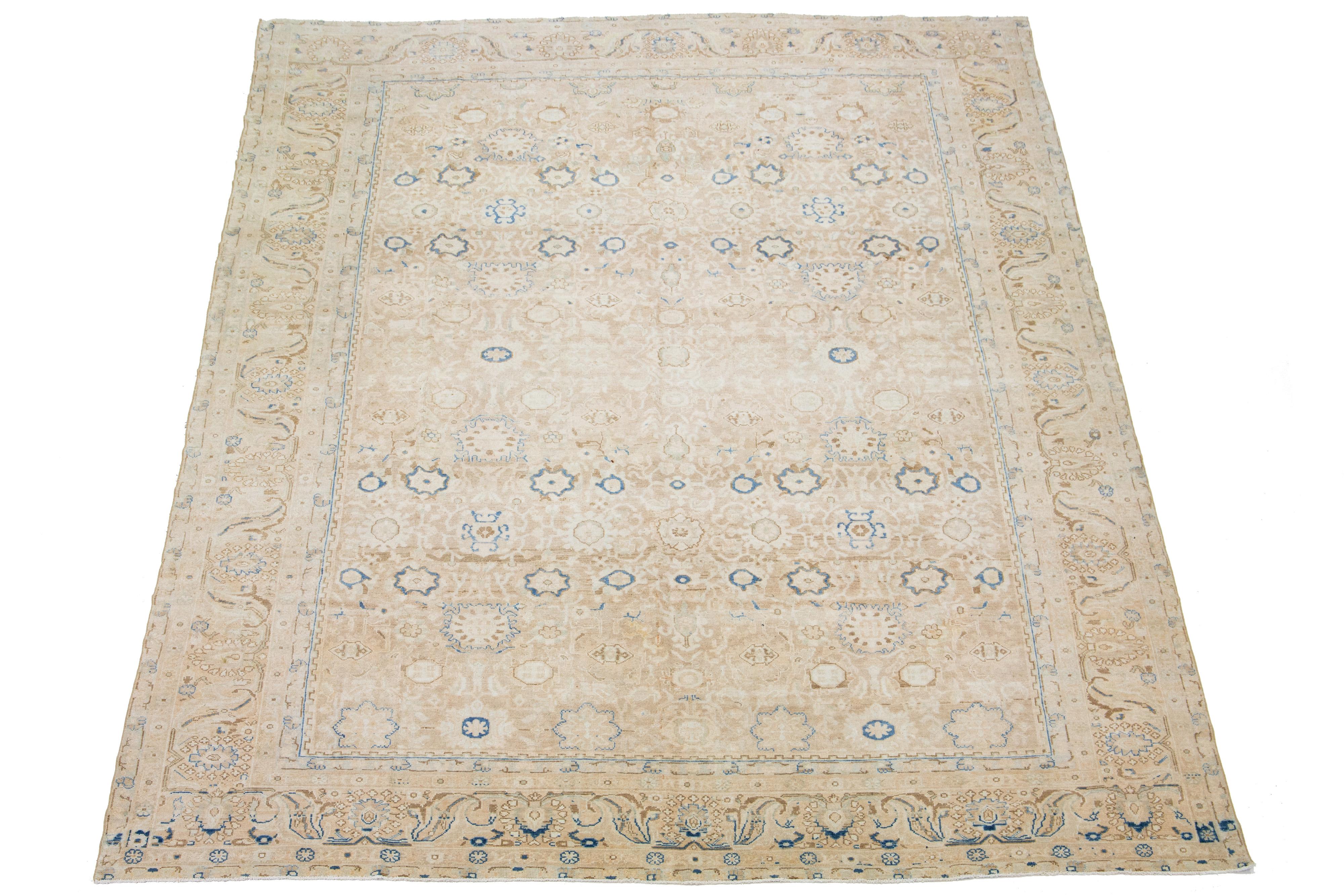 Beautiful antique Malayer hand-knotted wool rug with a beige color field. This Persian rug has a gorgeous traditional floral design with blue, brown, and gray accents.

This rug measures 10'3
