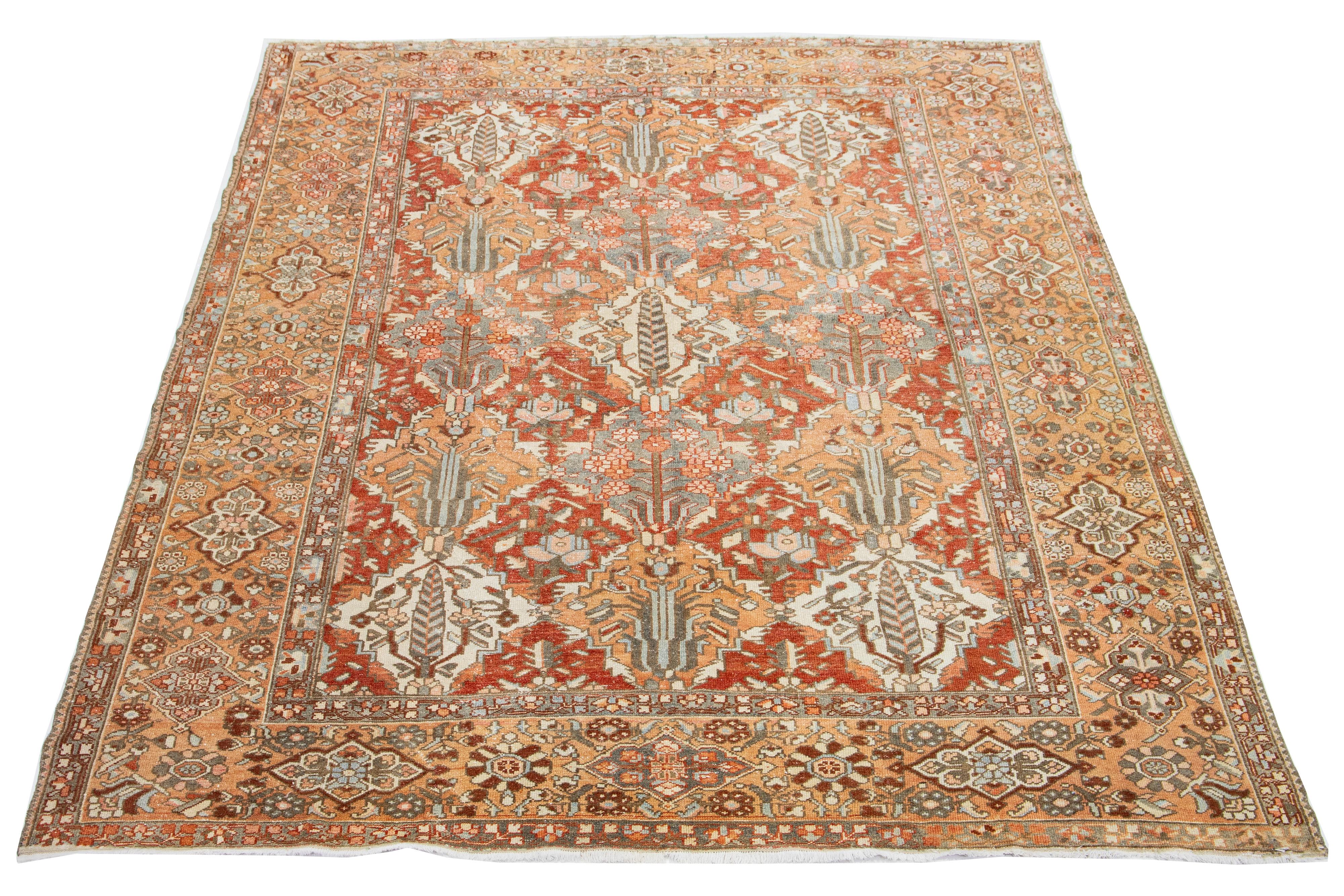 This beautiful antique Bakhtiari hand-knotted wool rug features a field of red-rust color. It showcases a classic Persian design with blue, beige, and orange floral colors.

This rug measures 9' x 12'.
 