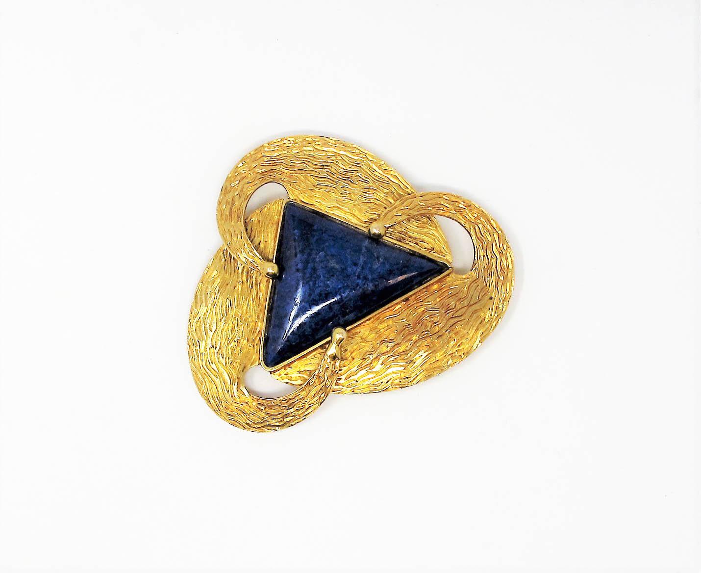 Gorgeous handmade lapis lazuli and 14 karat yellow gold brooch. This incredible piece is substantial in both size and design. The rich, variegated blue lapis stone really pops against the ornately carved yellow gold setting. This wearable work of