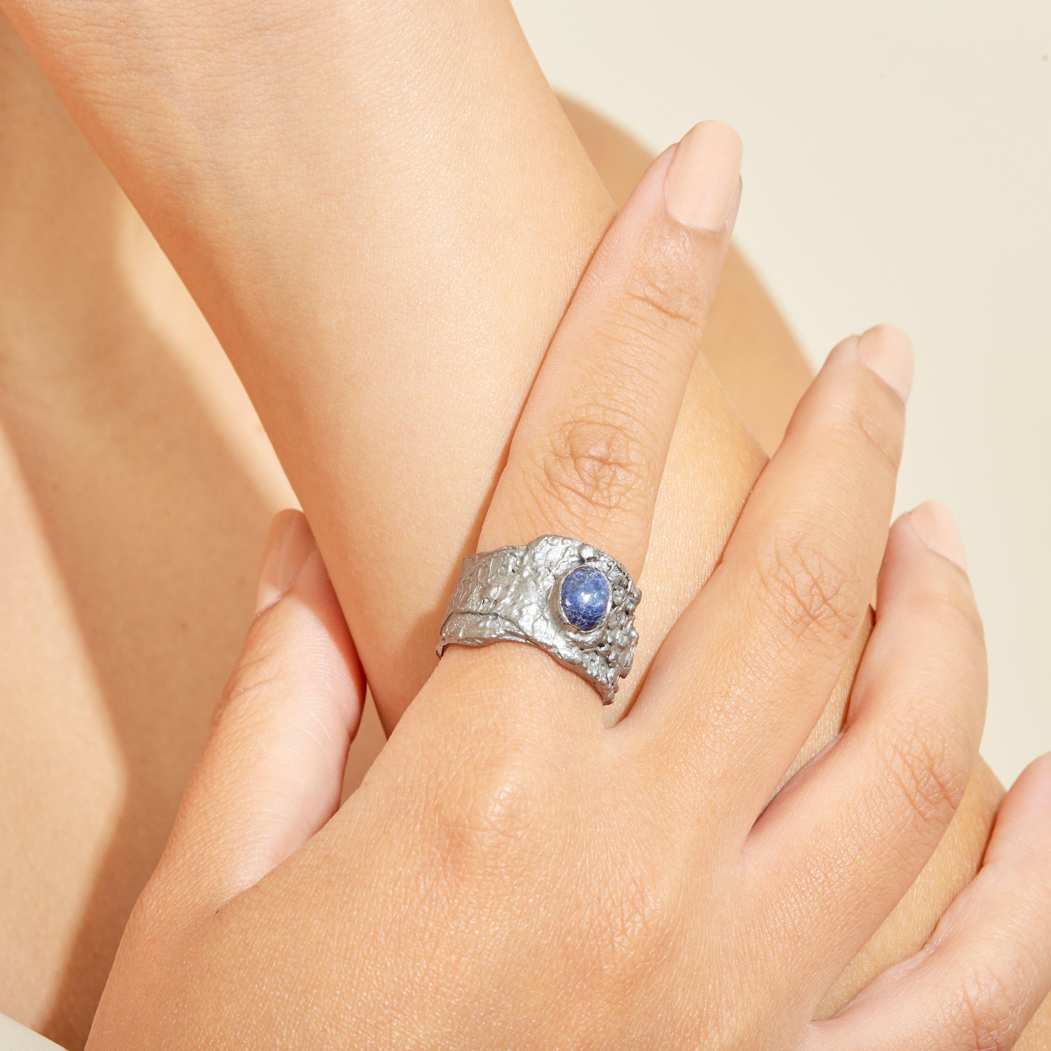 Black rhodium creates a dynamic looping cycle of life as it encircles itself. A powerful deep blue sapphire bursts forth from the depths of the precious metal and asserts itself with a symphony of colour.
