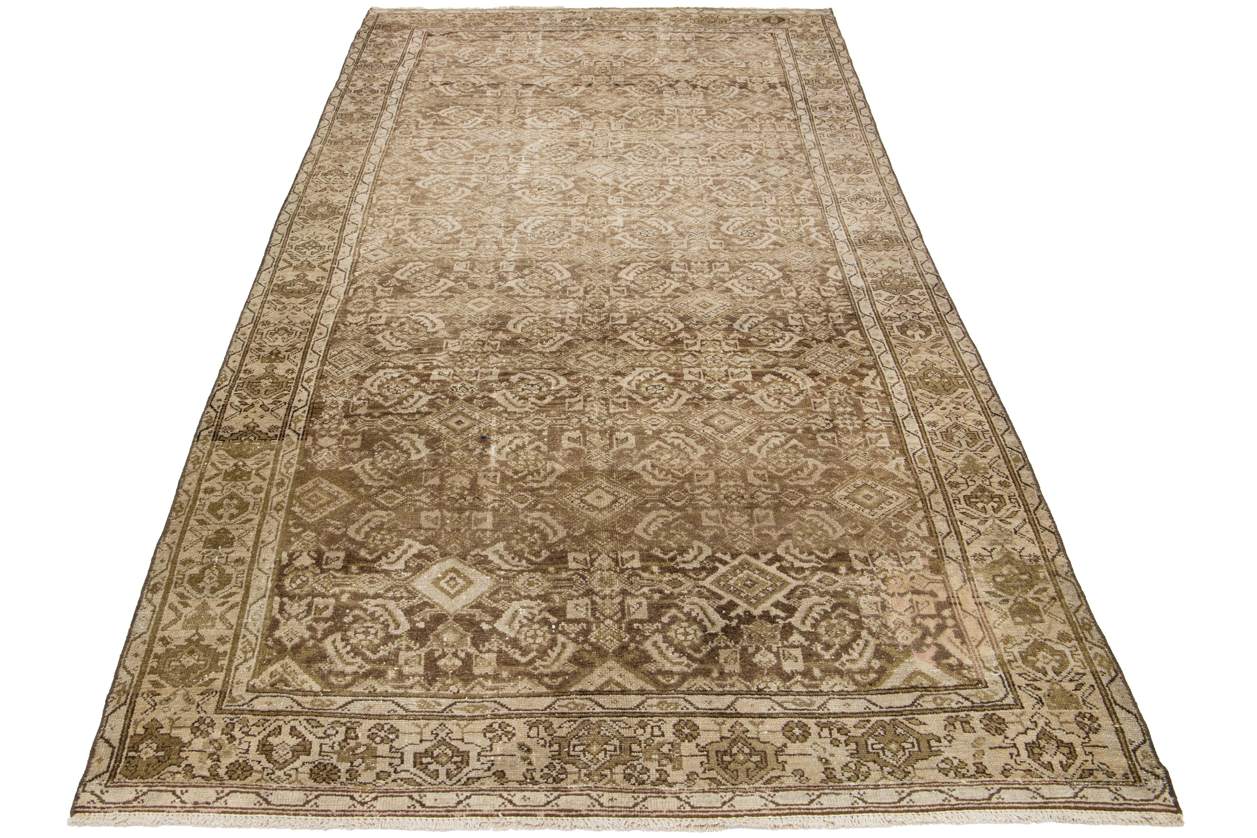 This is a handmade Persian Malayer wool rug from the 20th century. It features a beige field with brown accents throughout the design and is a large gallery size.

This rug measures 5'2