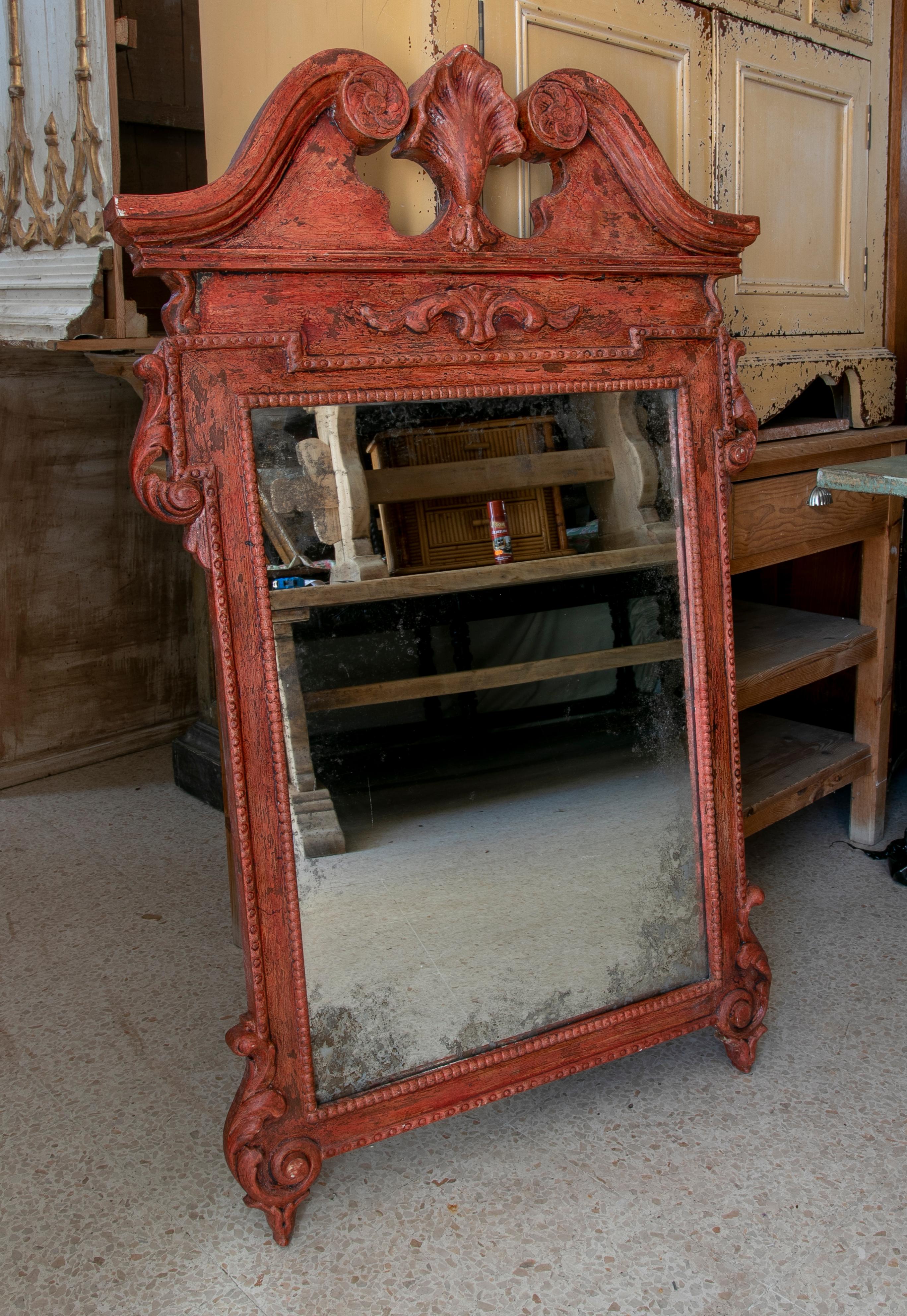 Handmade and carved wooden mirror in red colour.