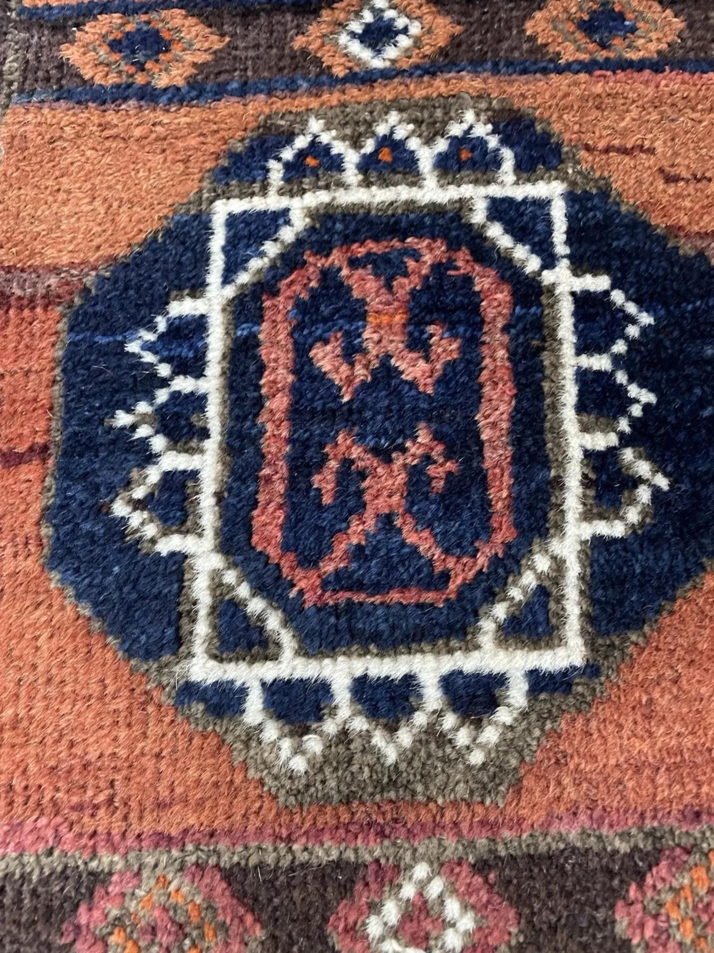 Possiedi un pezzo di storia nomade dell'Asia centrale con questo affascinante tappeto antico afghano Baluch, annodato a mano con lana tribale di alta qualità intorno al 1910. I tappeti Baluch, che prendono il nome dal popolo nomade che li tesse