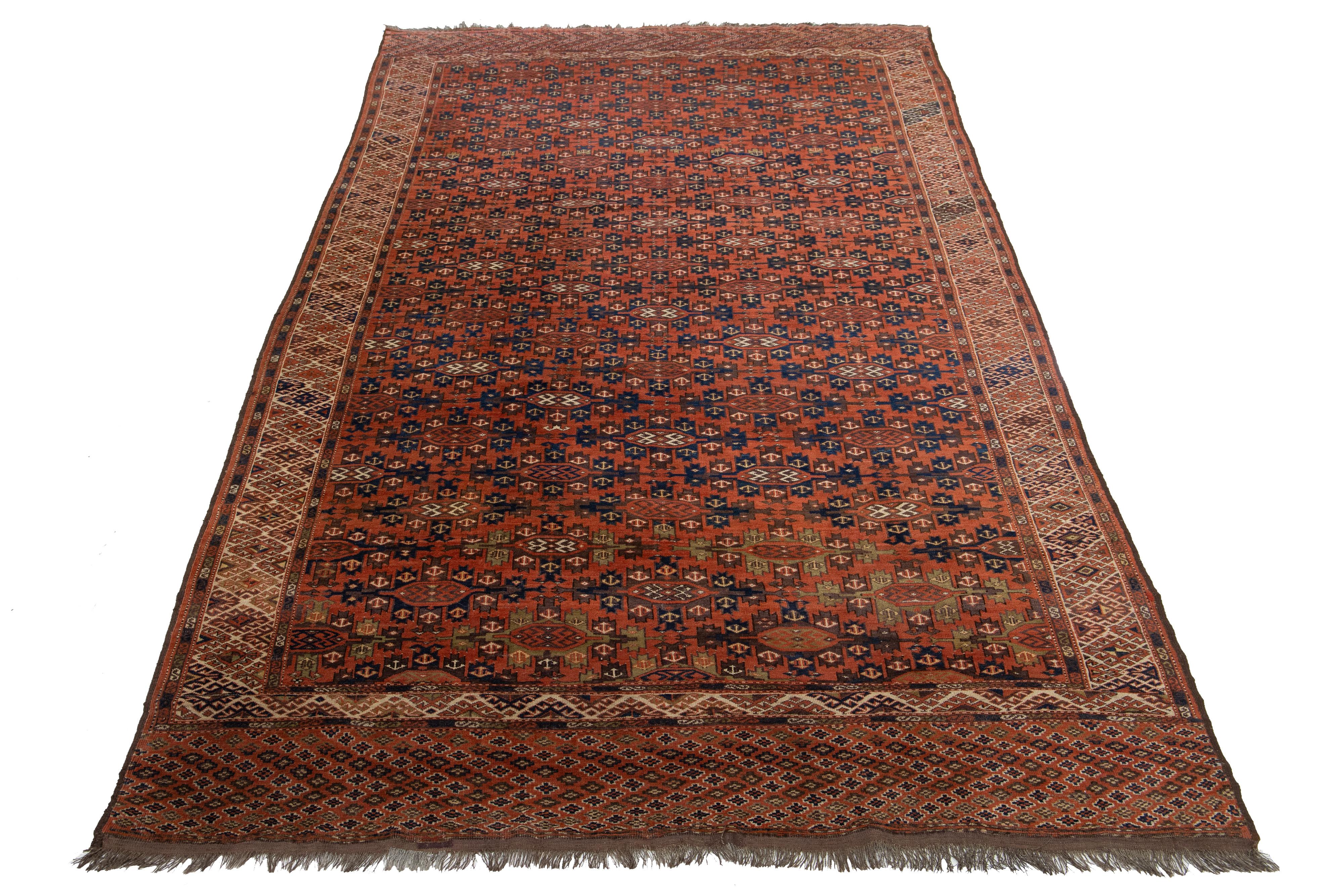 Ce tapis ancien en laine Design/One se distingue par sa couleur rouge rouille et son impressionnant motif géométrique dans les tons bleu marine et beige.

Ce tapis mesure 7' x 13'7
