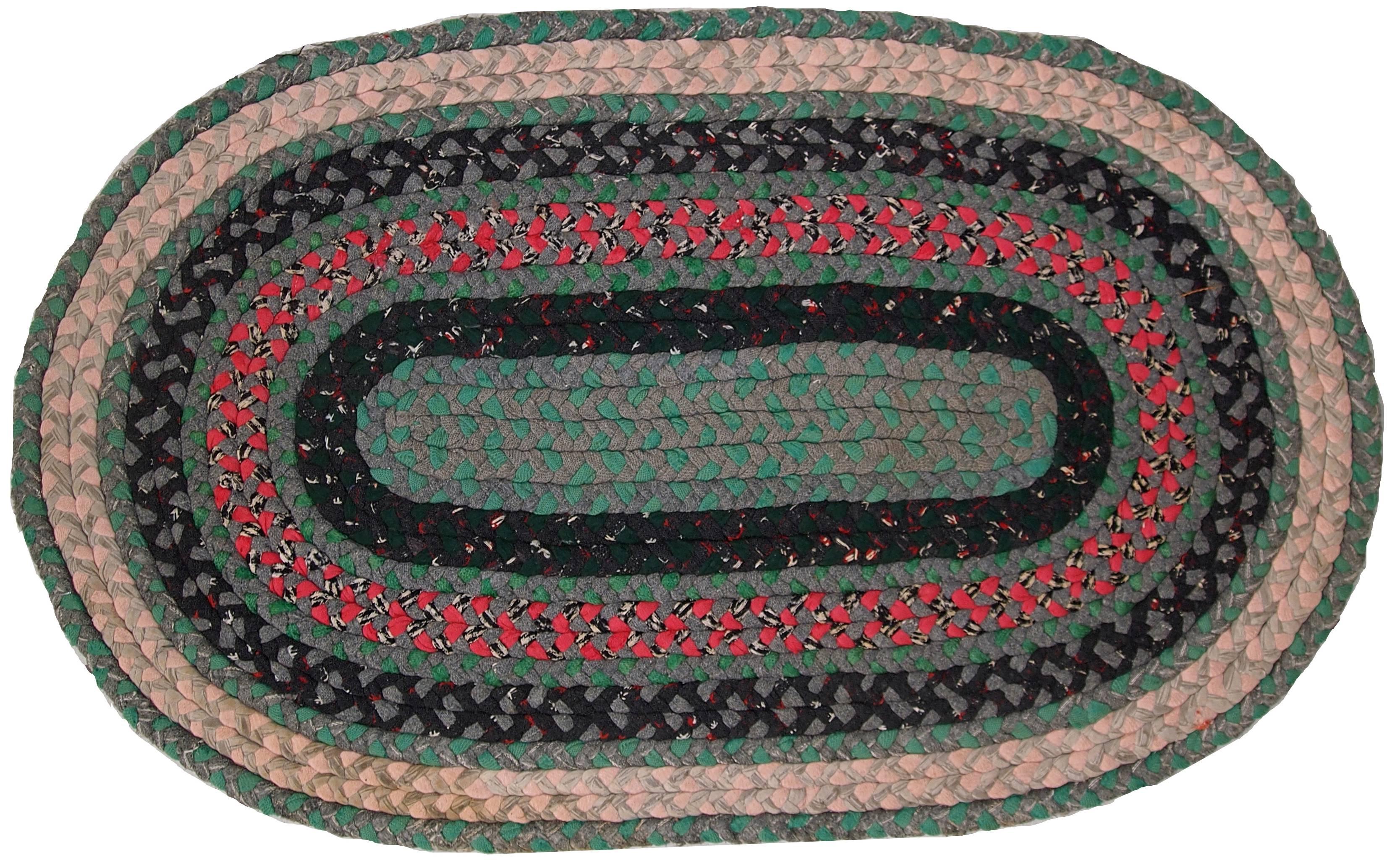 Handmade antique oval American braided cotton rug in green, fuchsia, and beige stripes. The rug is in original good condition.
 